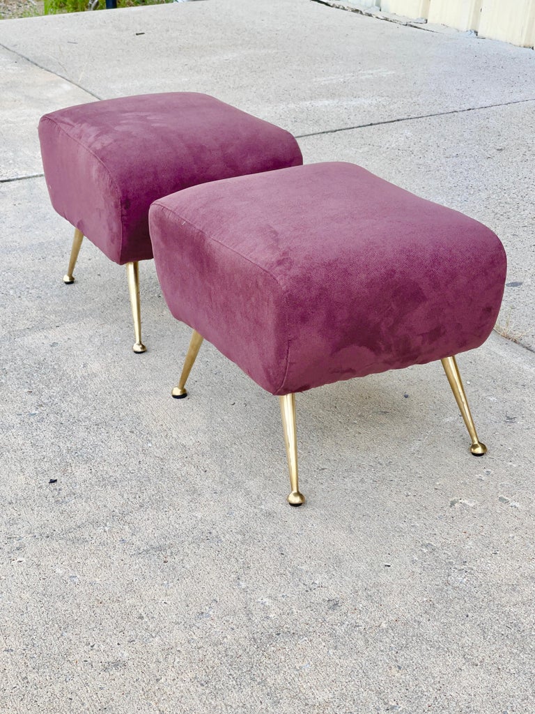 We have two matching footstools or ottoman, Italian 1950's, in rectangular slightly kidney bean shape. Wood frame upholstered in dense foam and covered in their original wine colored cotton velvet, each standing on four tapered solid brass legs with