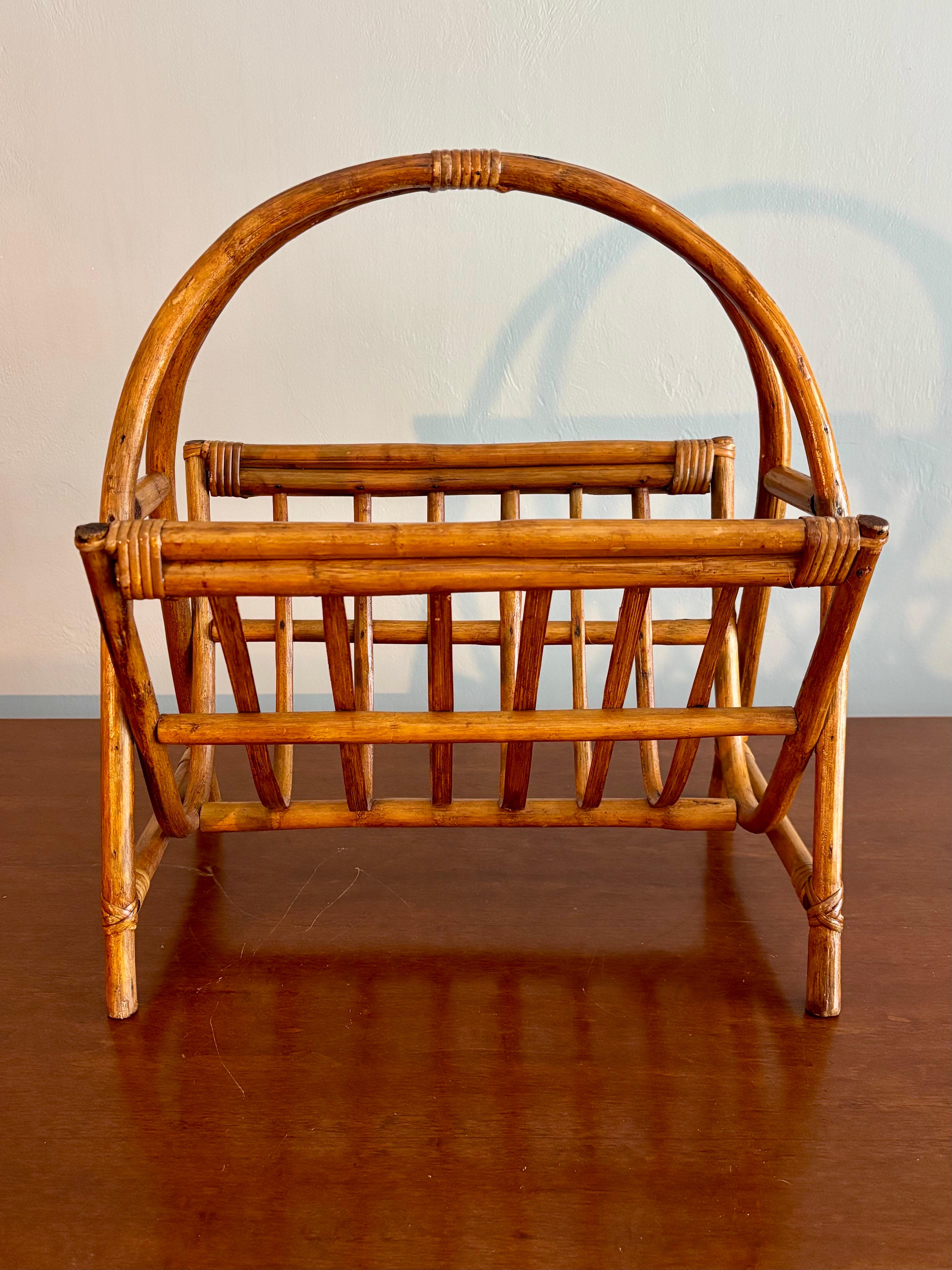 Magnifique porte-revues en rotin de la Côte d'Azur/Italienne. 

Dans le style de Franco Albini. 

Structure cintrée en rotin, enveloppée de canne. De fines lamelles de bambou pour créer la partie porte-revues. 

Légers signes d'usure dus à l'âge.