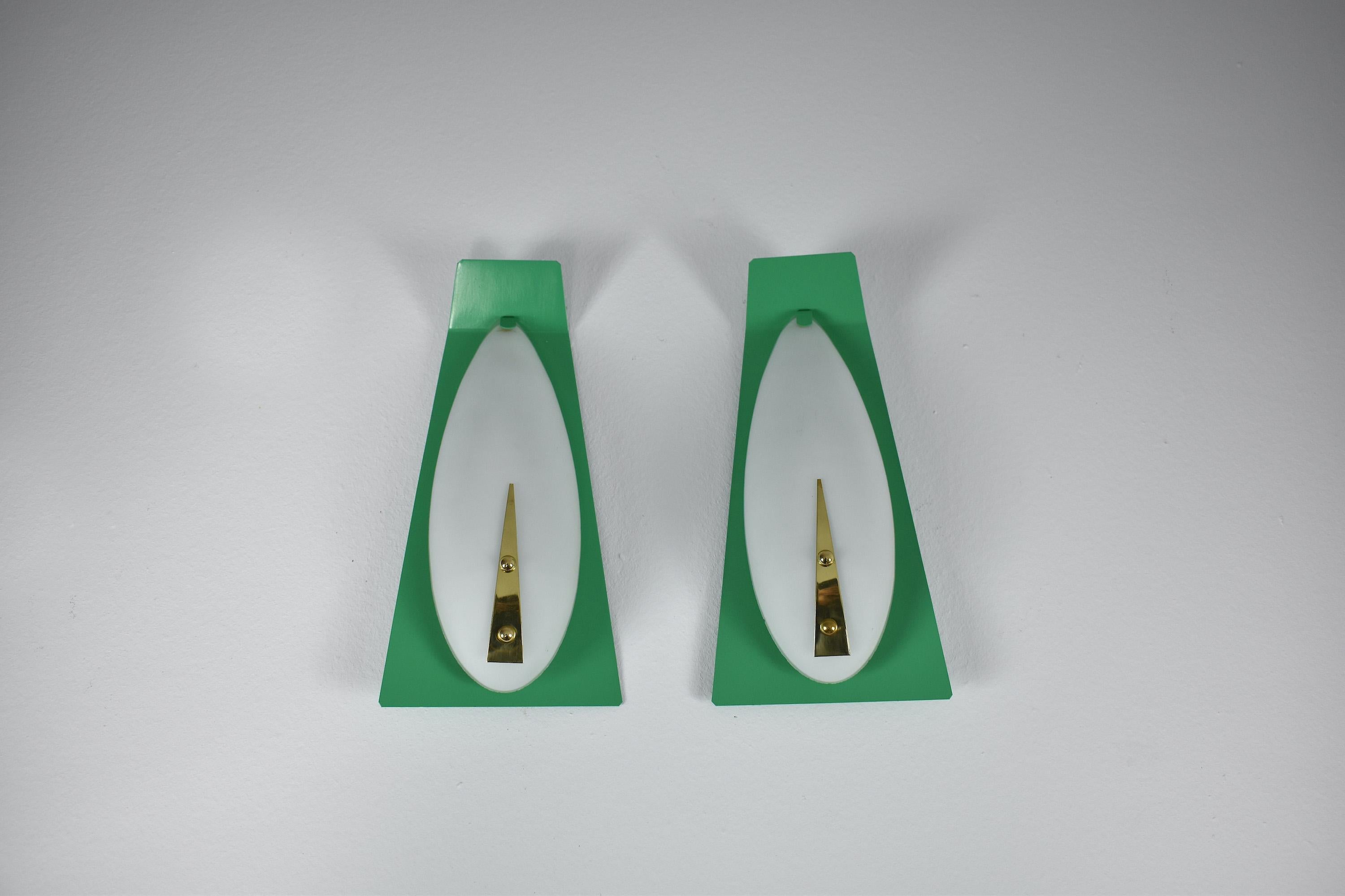 A beautiful geometrically shaped pair of Italian vintage sconces with white sandblasted round glass shades, sophisticated brass detail, and a mint green backplate. 
Italy. Circa 1950's.
In fully restored condition with a re-painted backplate and