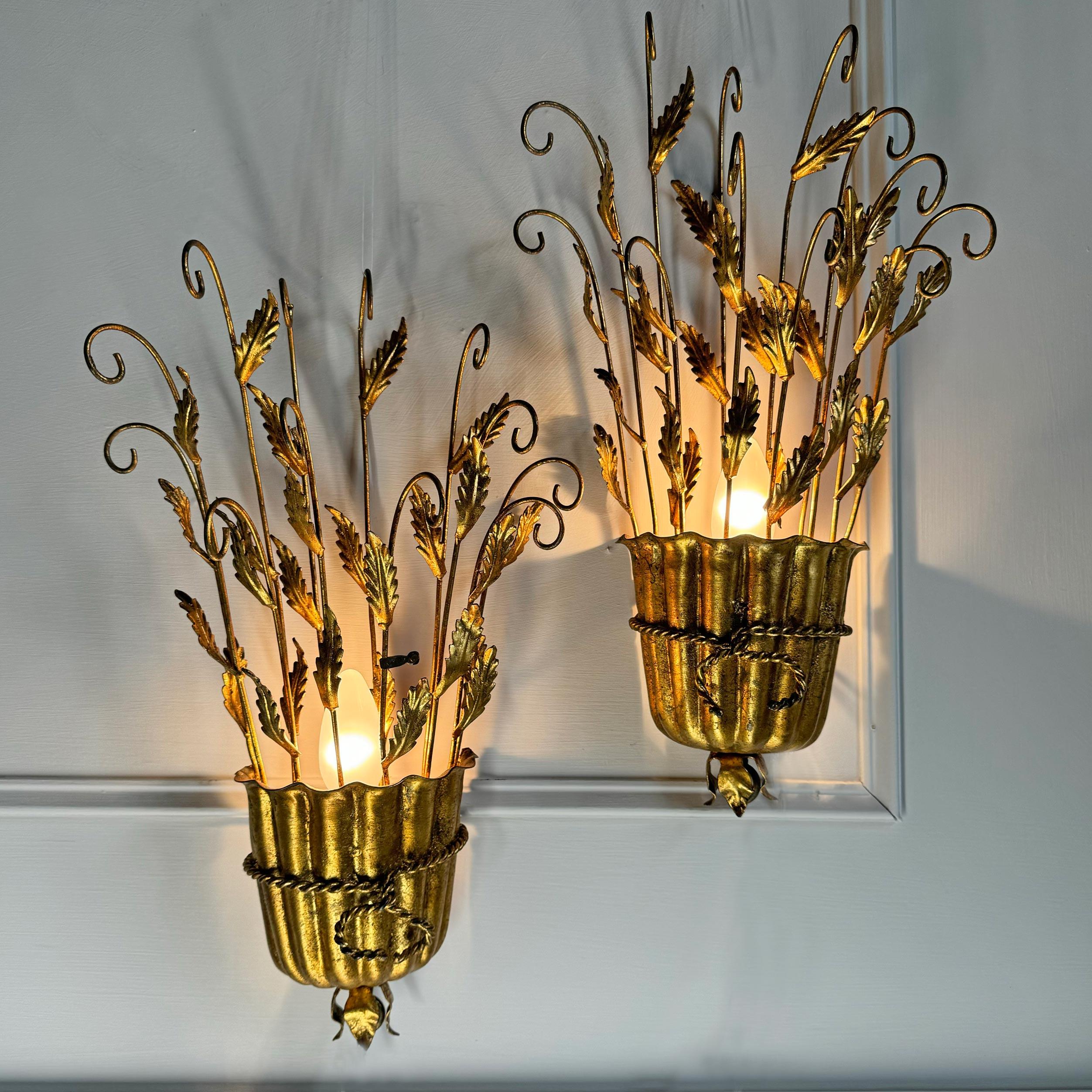 Incredibly detailed pair of Italian gilt leaf wall lights, modelled as scrolling branches adorned with leaves, all stretching out from a golden scalloped urn, with twisted rope embellishment.


Dating to the early 1950s’ Italian, each bearing the