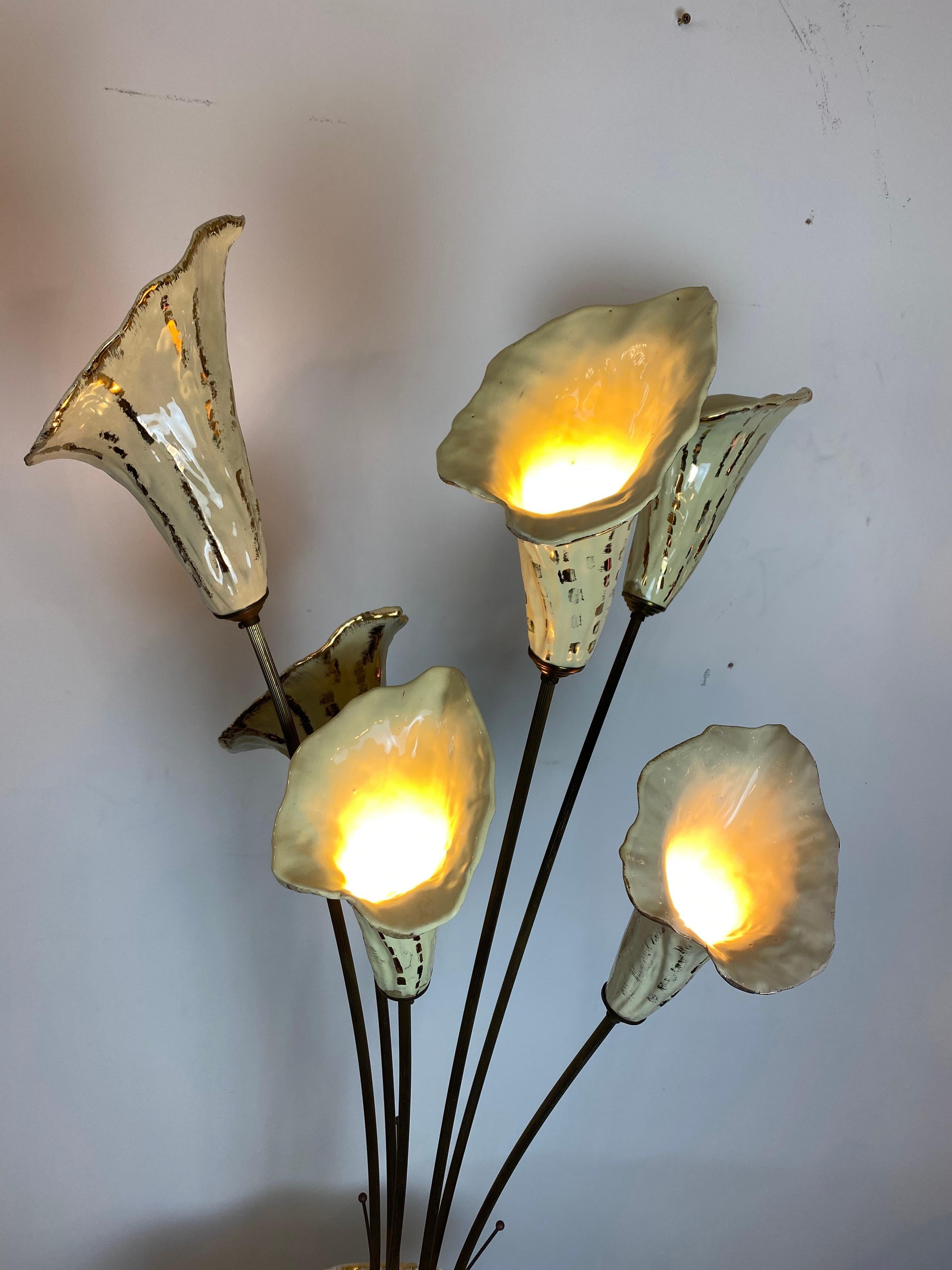 An extraordinary Italian ceramic floor lamp depicting a vase with 6 tall Lilies on brass stems, each holding a lamp. The tall vase is hand painted with Alpine scenery, gilt details and sits on a brass surrounded wood base.