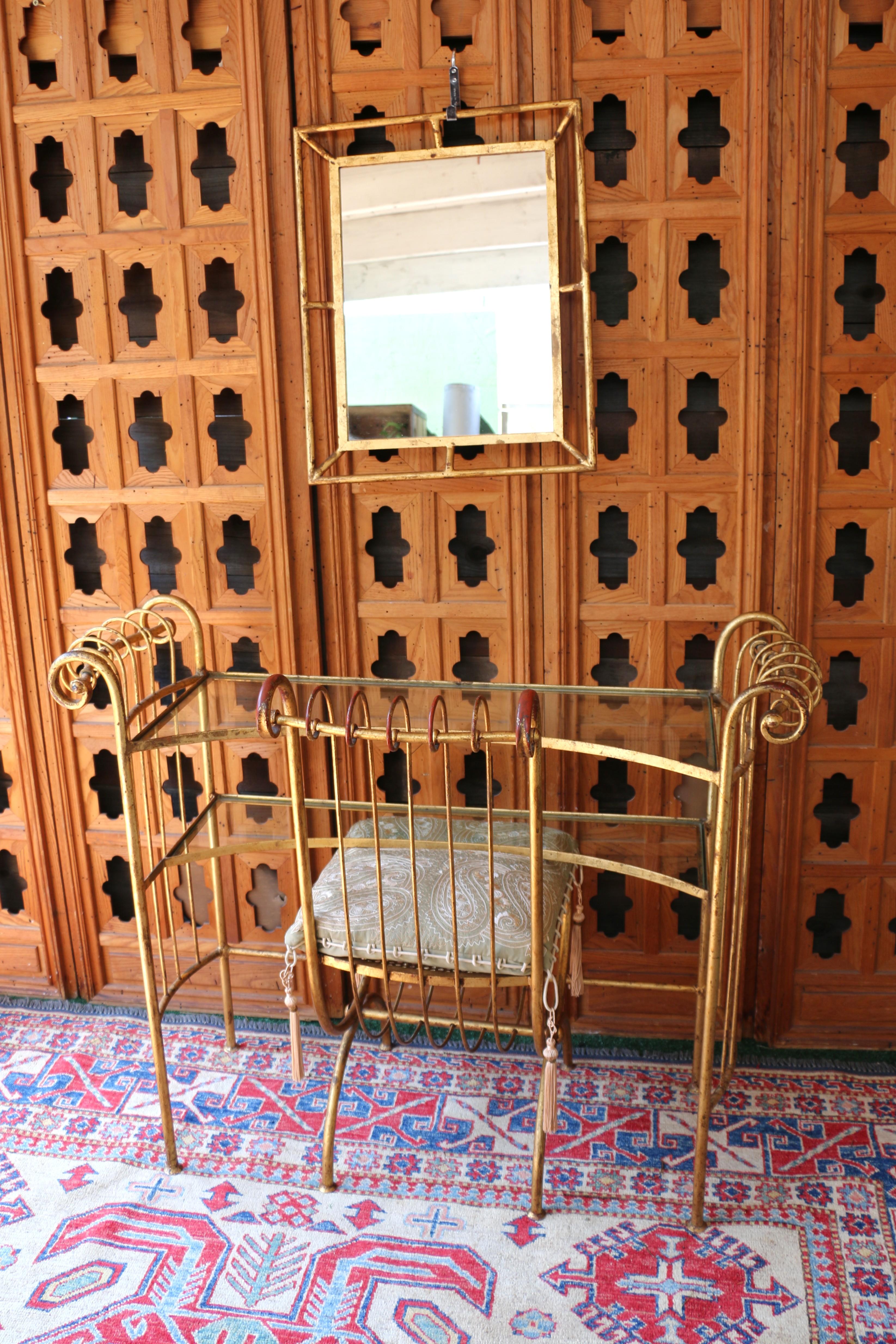 Merveilleux ensemble de coiffeuse vintage, comprenant un miroir, une table de toilette et une chaise. L'ensemble présente une finition dorée avec des détails ornementaux, et la chaise est dotée d'un coussin à motif cachemire avec des glands. La