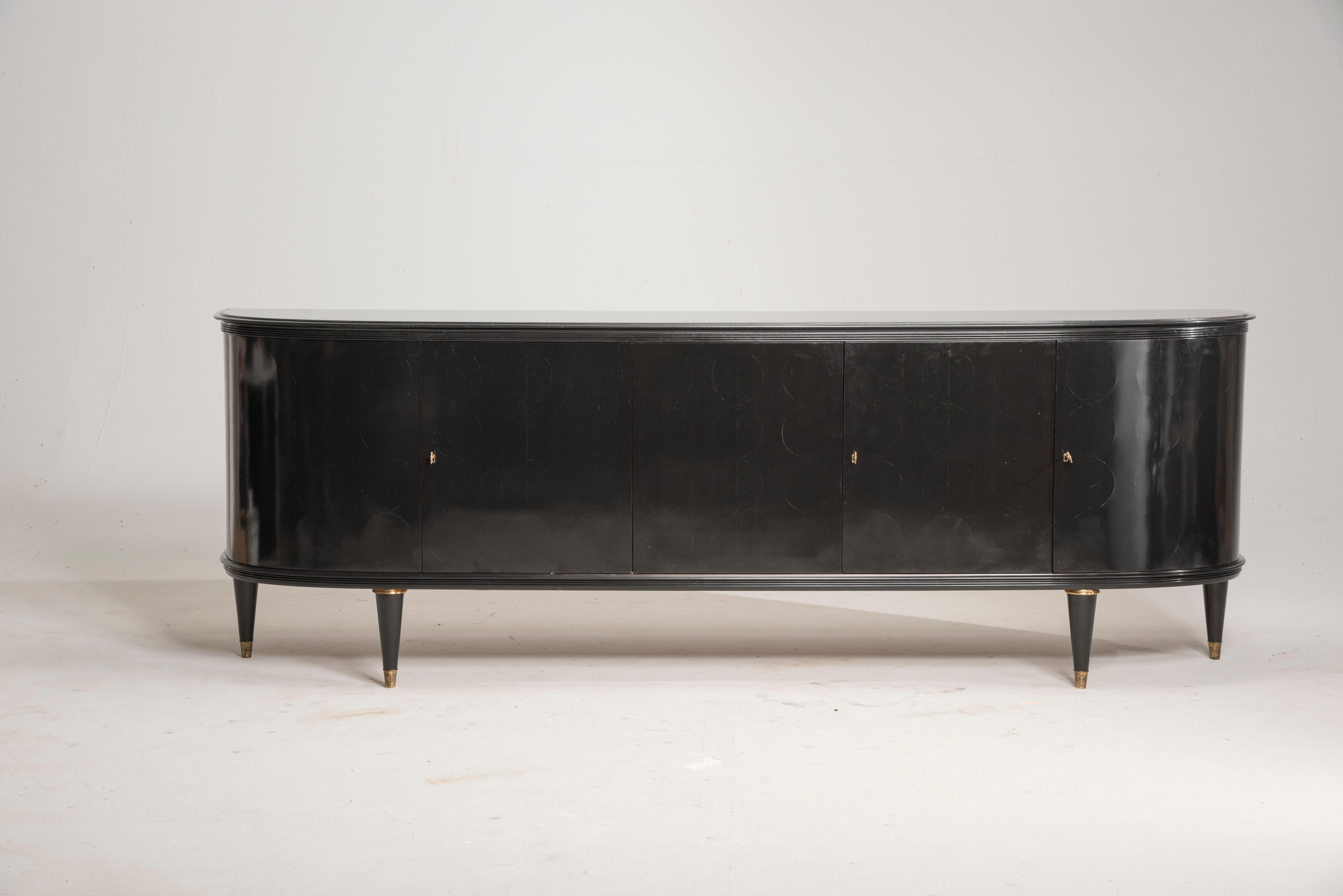 1950s Italian long rounded edges crystal top black buffet with brass feet.
From Italy from 1950s period. Three doors internally are arranged with one shelf. Originally it was in wood color but In the past this has been lacquered in black, we have