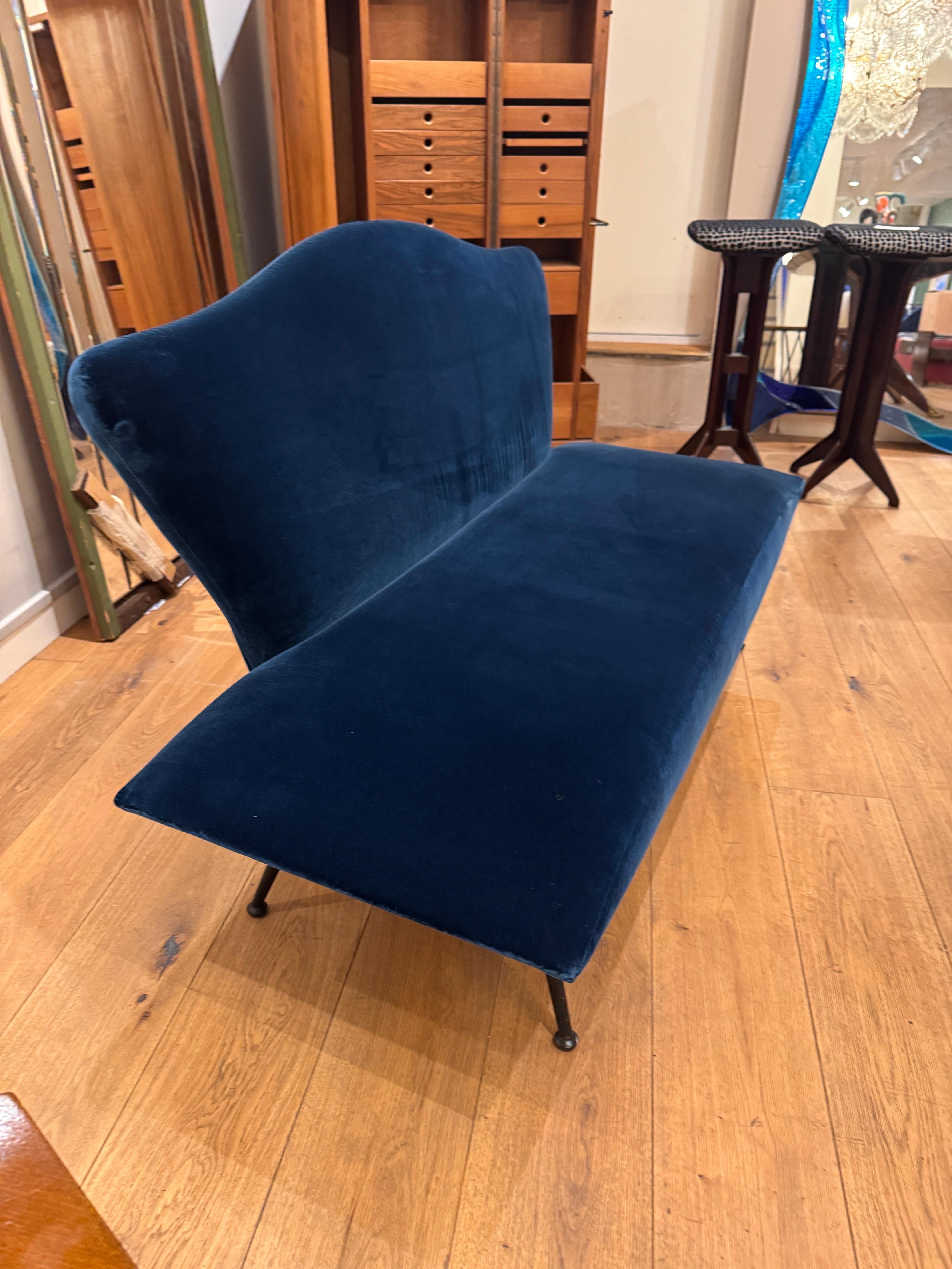 A wonderful loveseat bench with sculpted back standing on black metal legs recently upholstered in lush teal velvet . 
Designed C1950 . Italy 
