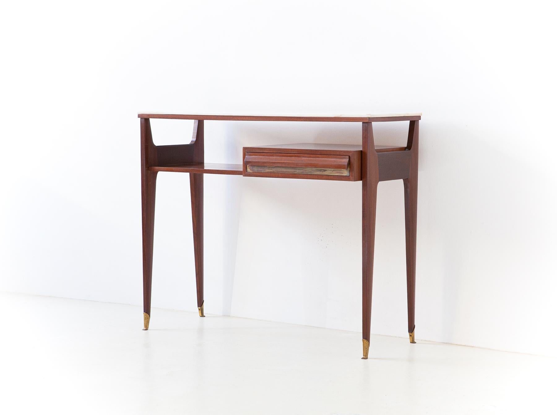 Italian console table with drawer, manufactured during the 1950s

This Mid-Century Modernist console is crafted from solid mahogany wood with brass details with its beautiful original patina and marble top. It has a drawer on the right.
Its