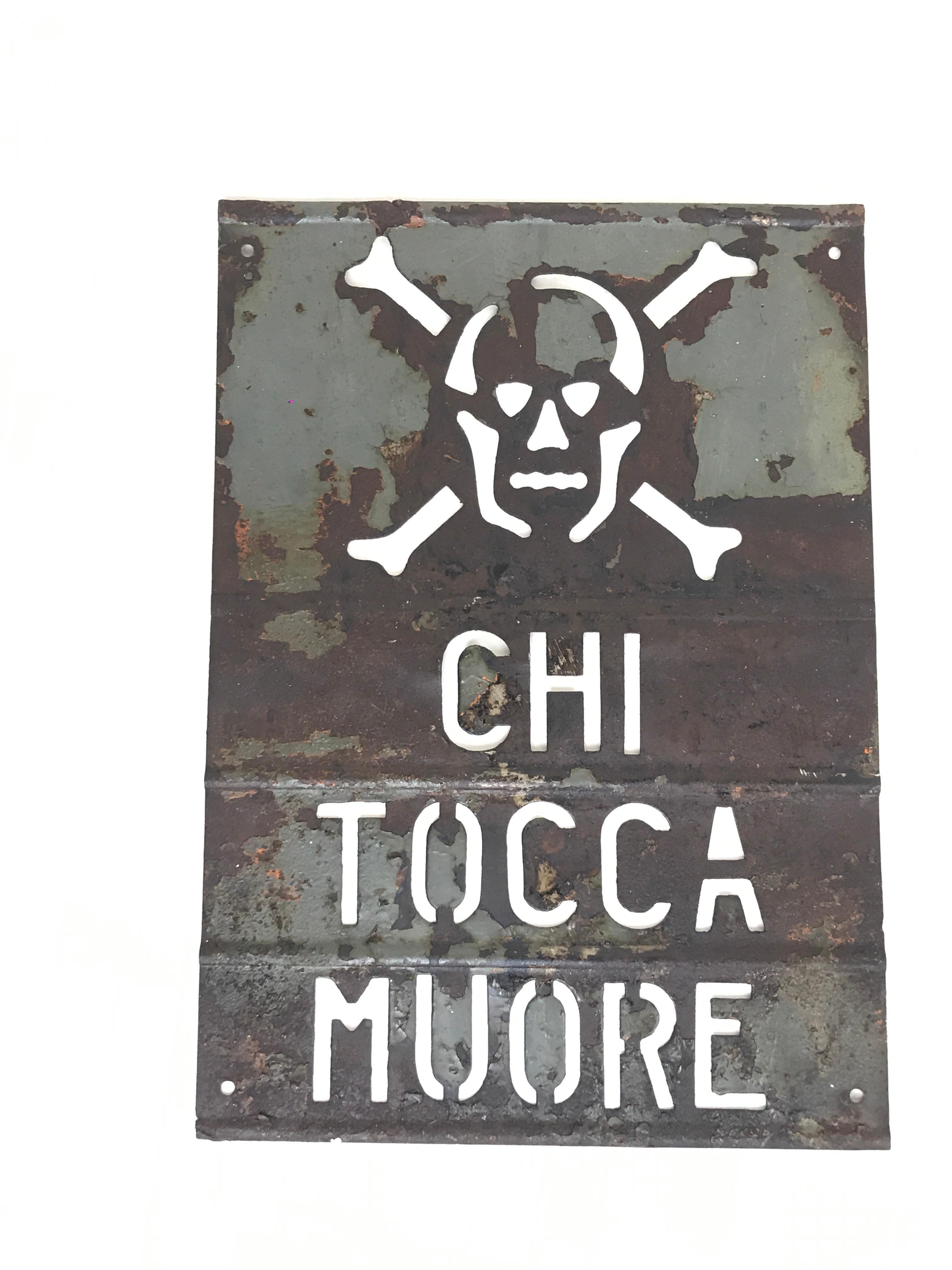 Vintage metal danger high voltage (Chi Tocca Muore) safety sign.
The sing is perforated and shows the symbol of skull and bones in the upper part.

The sign presets traces of grey painting.