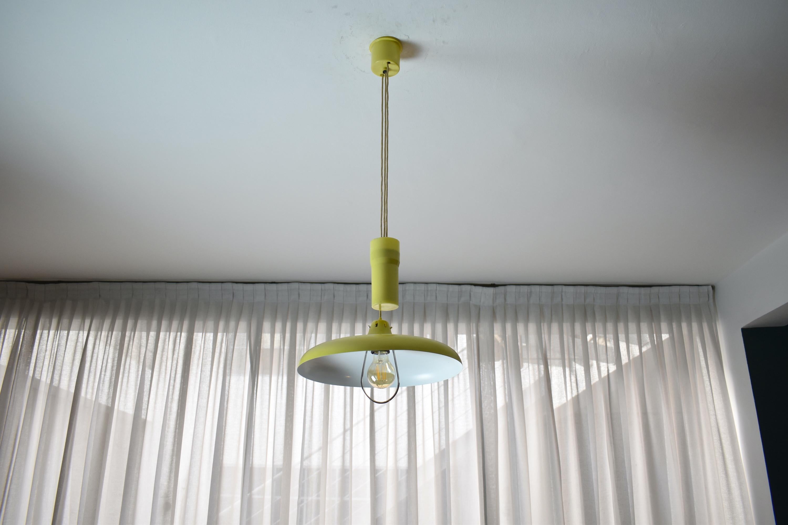 A fantastic 20th-century vintage pendant by collectible Italian manufacturer Stilux Milano which adjusts in weight via its counterweight design made of perspex. The light is brilliantly designed with a pulley under the shade. The apple green color