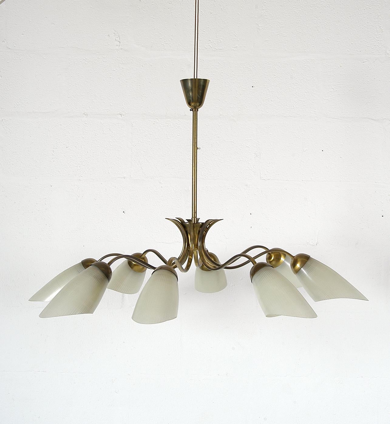 A lovely example of a 1950s Italian Mid-Century Modern chandelier comprising of eight curved brass arms emanating from the central shaft. Each arm supports a cream coloured curved glass ‘cheese-cloth’ textured shade.
The light has been fully
