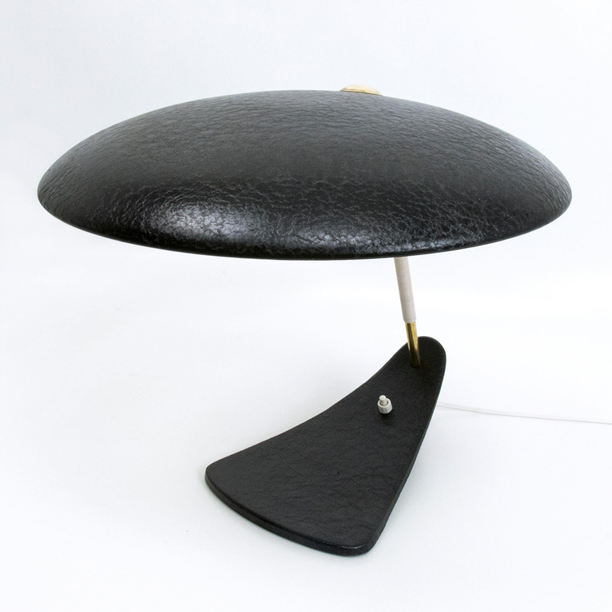Splendida lampada da tavolo italiana della metà del secolo scorso con finitura laccata nera e asta in ottone con cavo bianco.
La lampada da tavolo ha un grande paralume rotondo e una rara base a forma di becco in ghisa.
Fantastico design minimalista