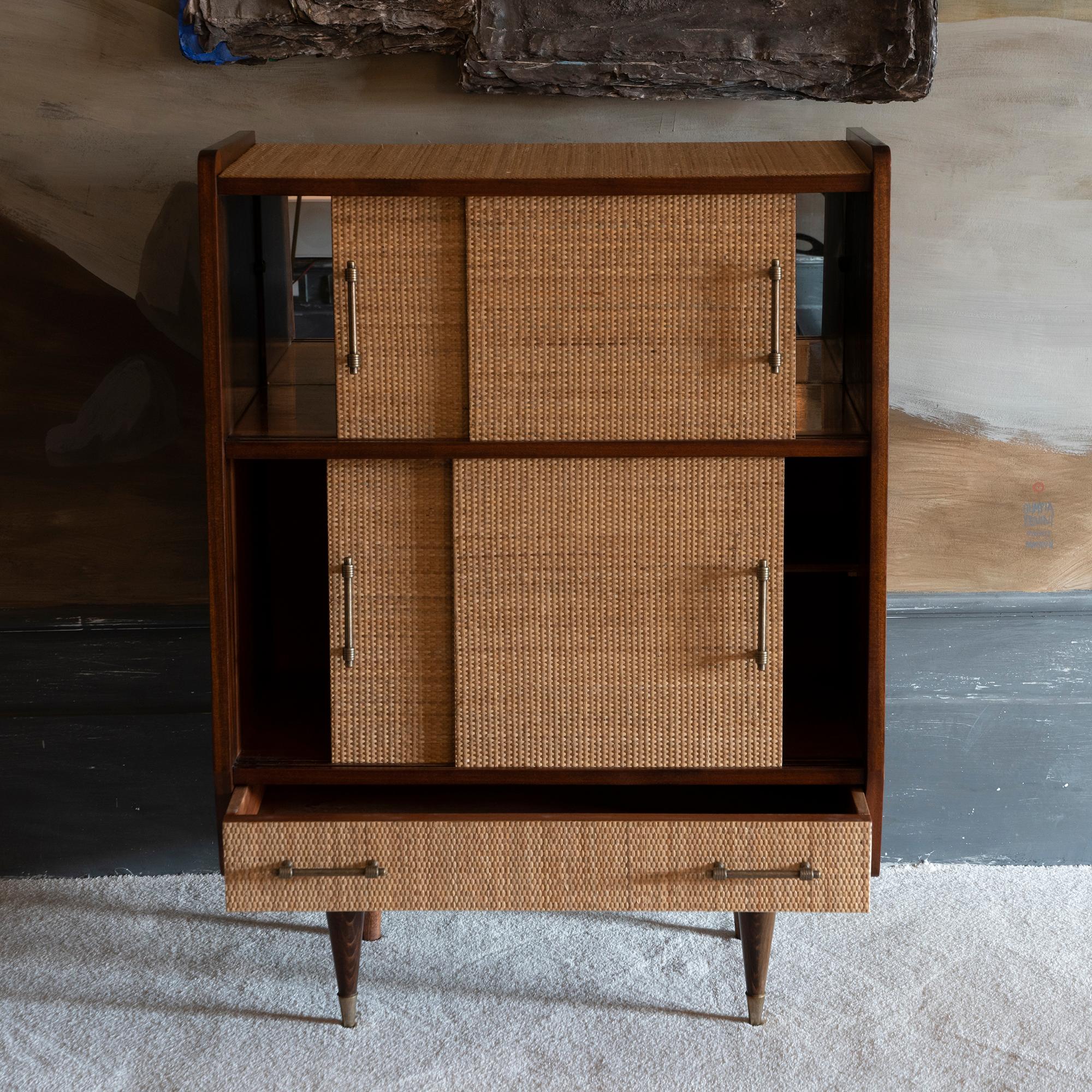 Mid-Century Modern wood and rattan dry bar cabinet, perfect condition and vintage patina, sliding doors and original mirrored glass and brass details, Italy 1950s circa.