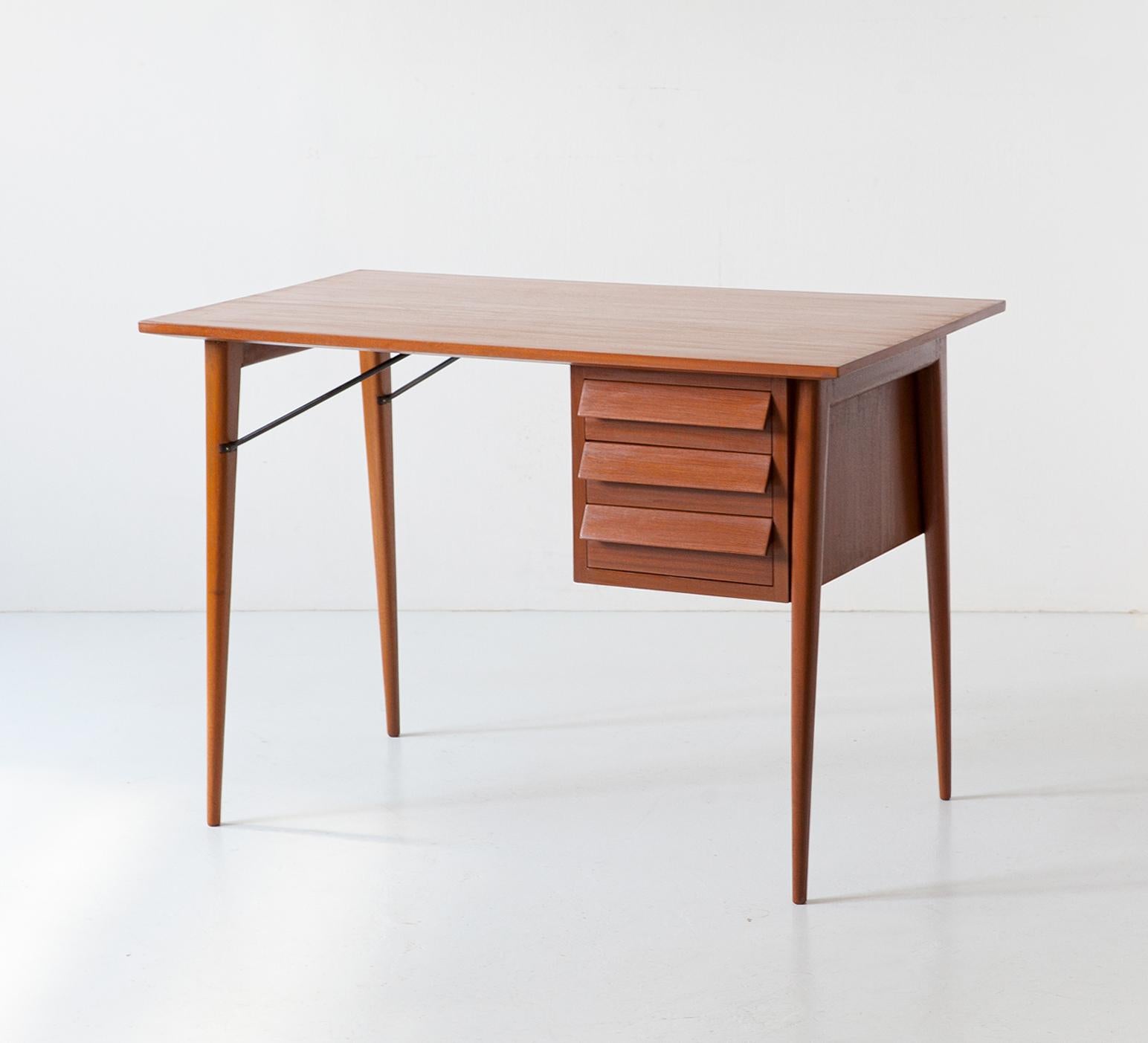 Italian desk with three drawers, 1950s 

This desk is made with parts in solid mahogany and others with mahogany veneer, there are also two steel rod fittings to support the legs. It has been completely restored with the complete removal of the