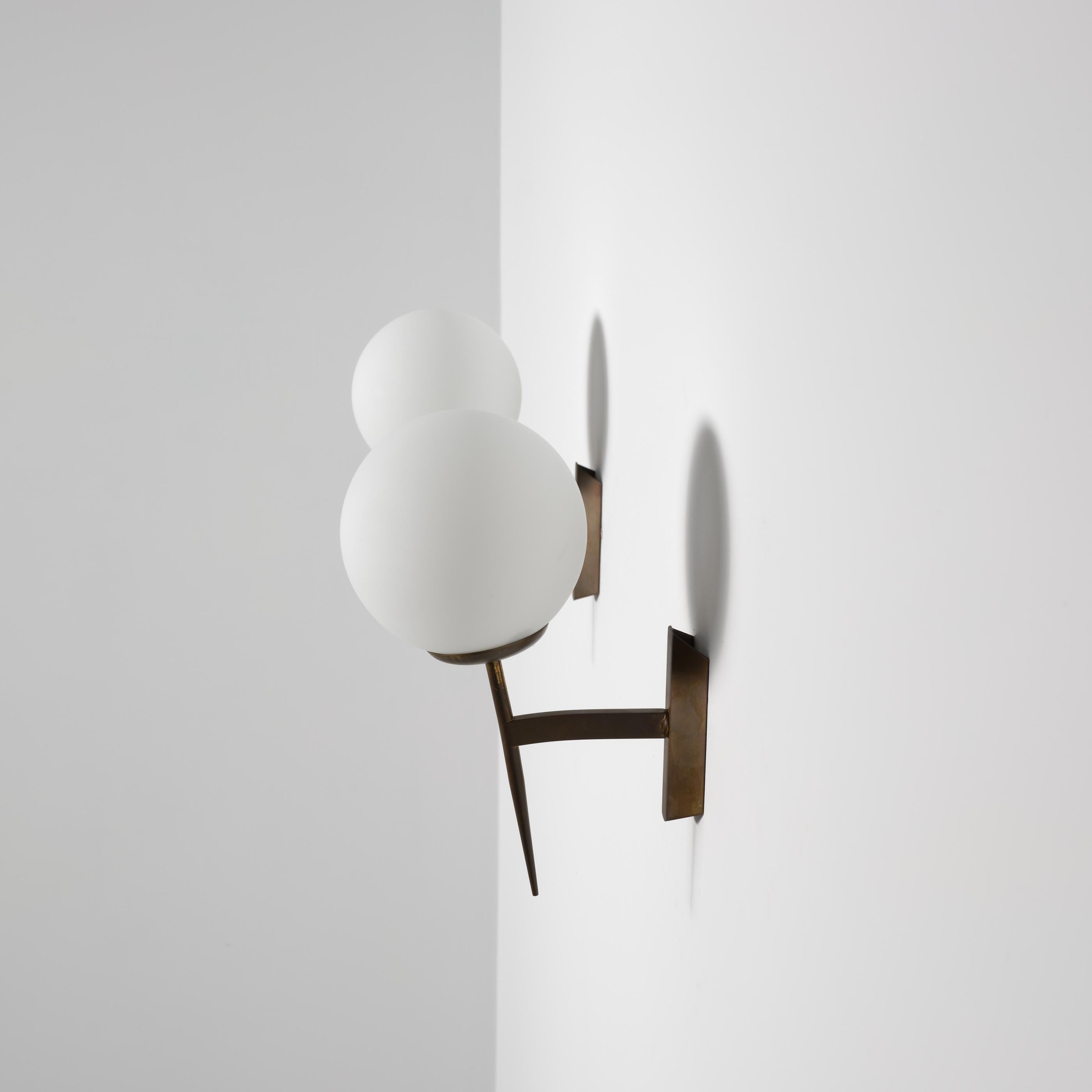 Este par de apliques de pared italianos de la década de 1950 presenta un diseño refinado y moderno caracterizado por líneas limpias y proporciones equilibradas.
Cada candelabro está fabricado en latón, con una pátina envejecida de forma natural que