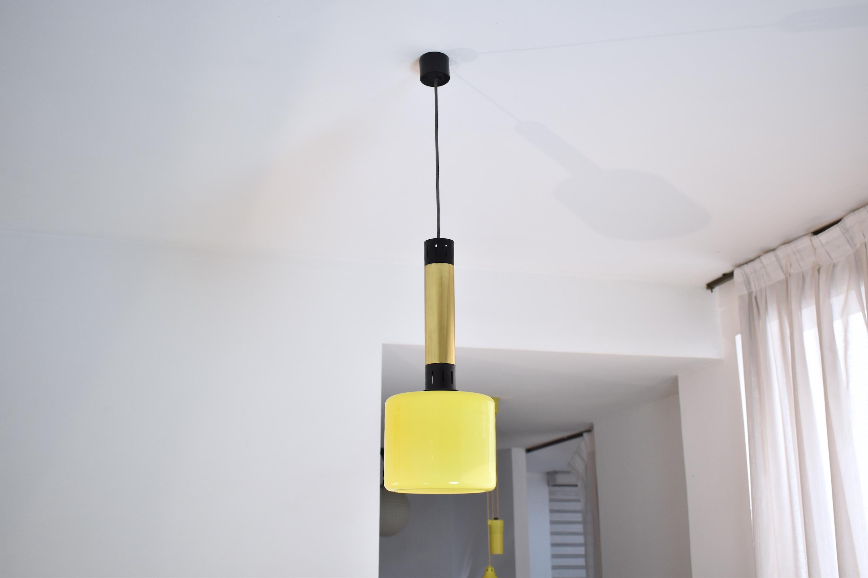 20th-century vintage pendant by Stilnovo designed with one yellow Murano handblown glass shade. The structure is composed of a long black lacquered aluminum and a polished gold brass structure.
Italy. Circa 1950's.
This piece is professionally