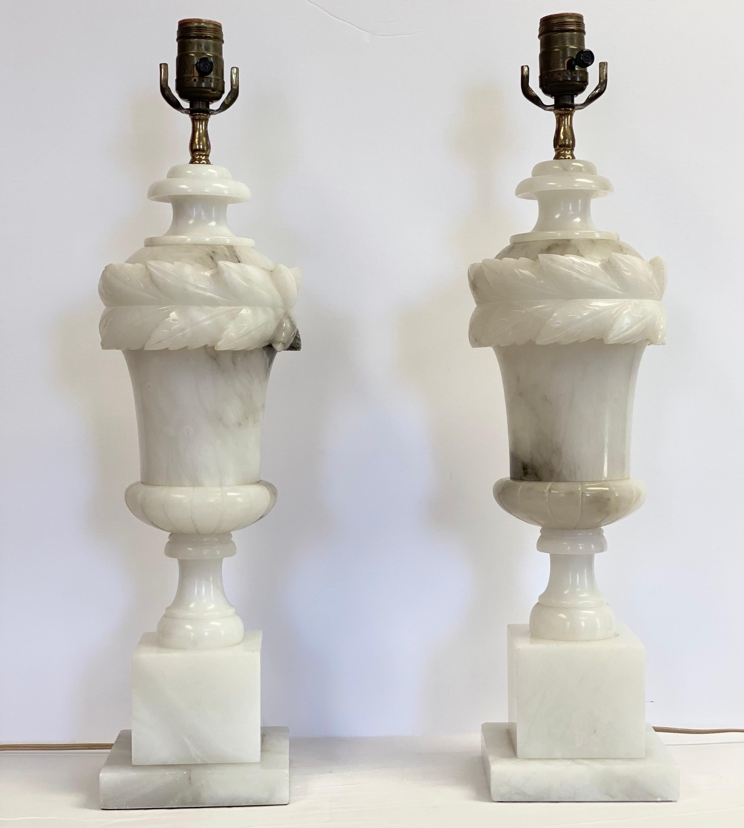 We are very pleased to offer a pair of traditional, Italian table lamps circa the 1950s. The intrinsic beauty of white marble stone shines through this handcrafted pair. To attest to its elegant and refined look, each piece is carved from white
