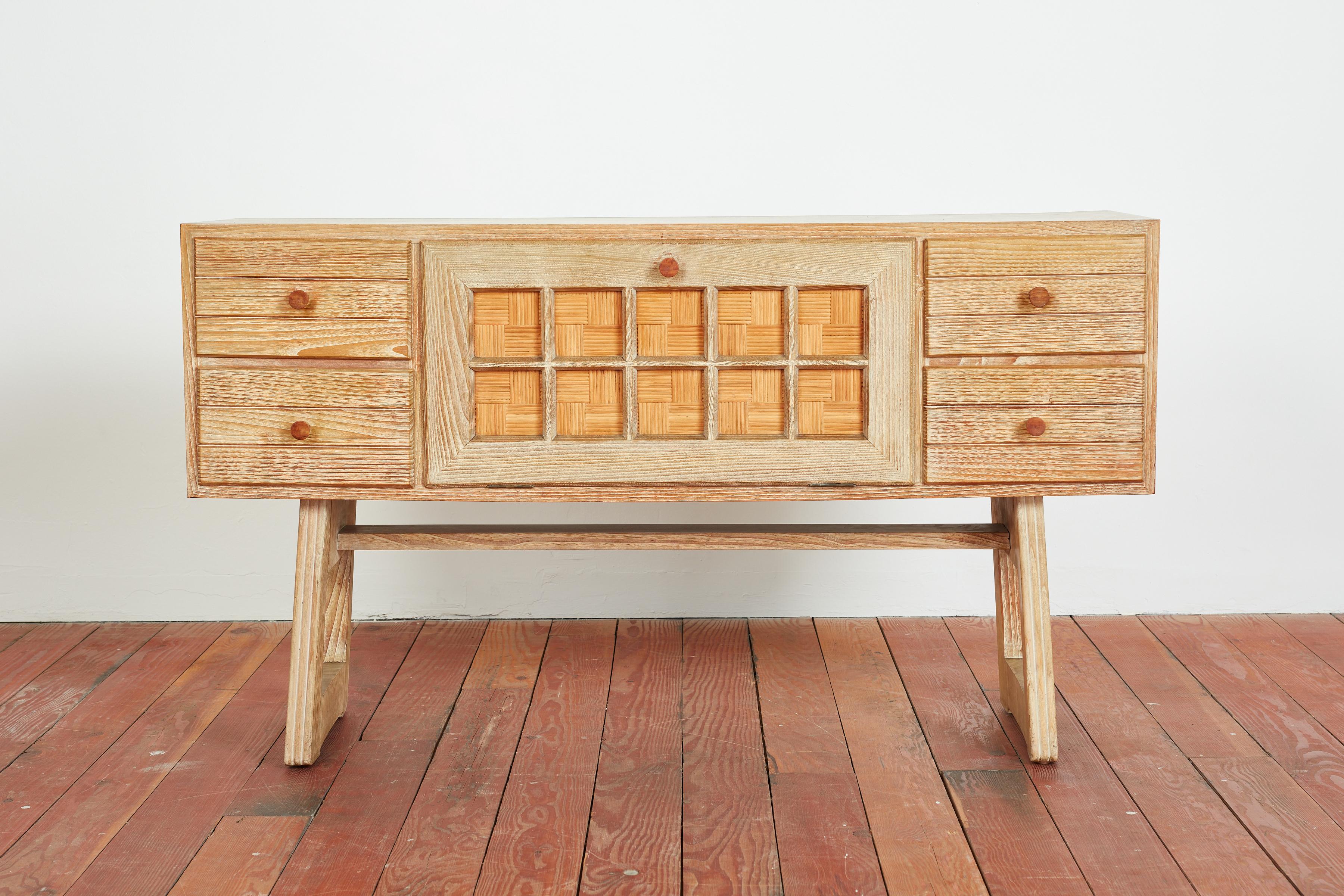 Unique Italian sideboard in sandblasted oak with woven rattan drop front and drawers on both sides. 
Wonderful grain in oak
Italy, 1950s