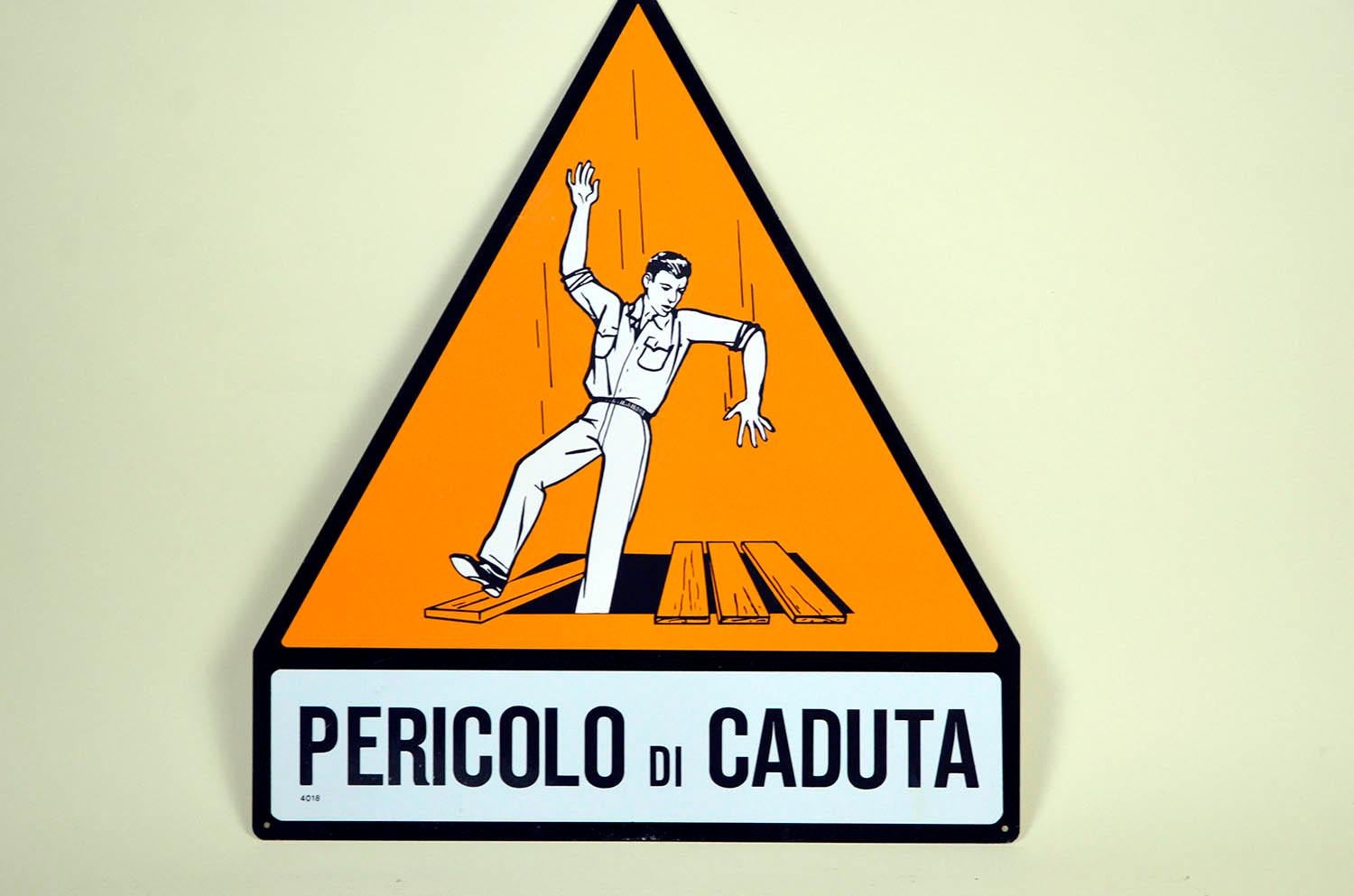 Orange, black and white triangle metal fall hazard ( pericolo di caduta ) safety sign.
This screen printing safety sign was produced in 1950s in Italy and it was in use within the Italian factories.