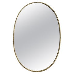 Miroir italien des années 1950, ovale, encadré de laiton, avec bordure perlée