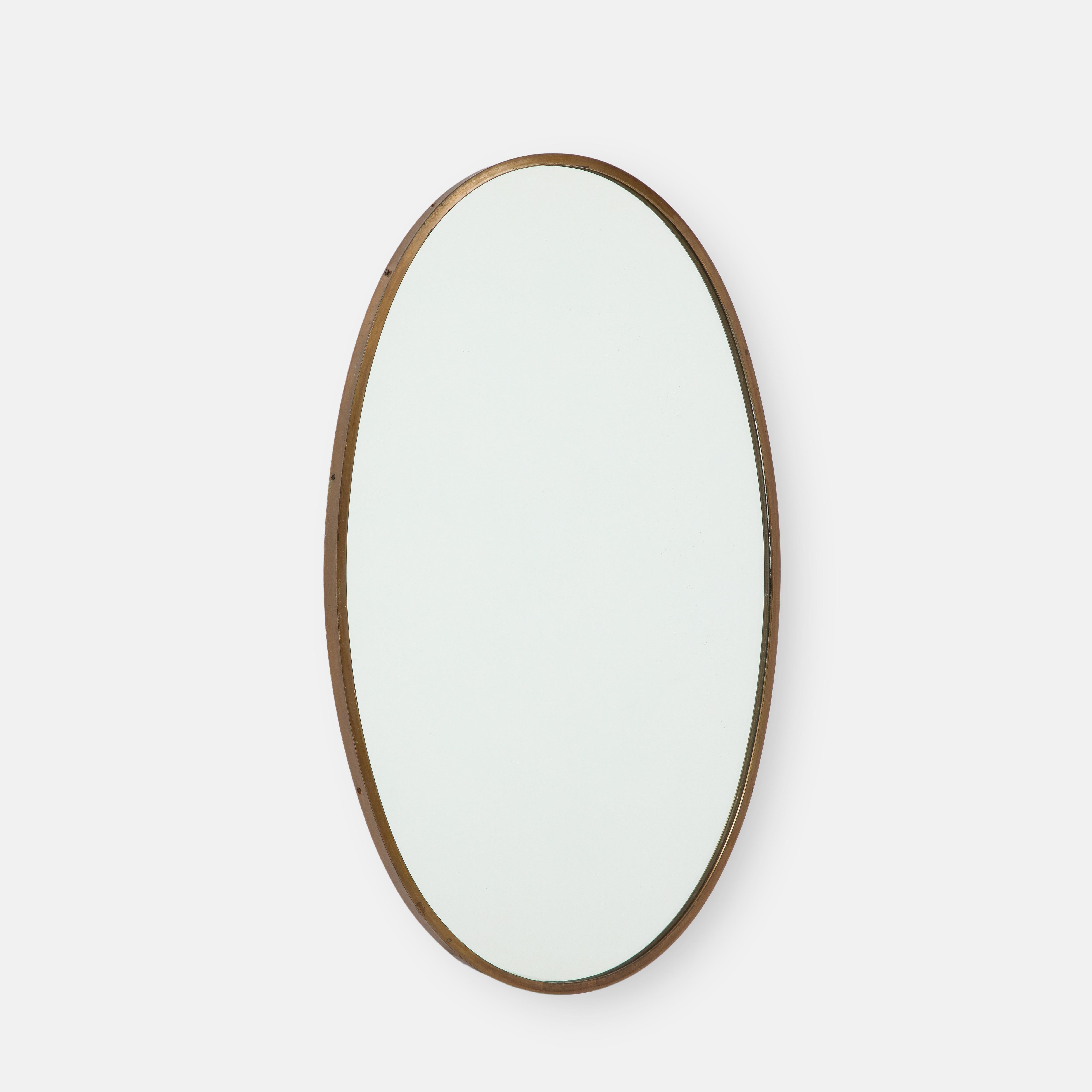 1950s Elegant Italian oval brass wall mirror with a rich patina on the brass frame, original mirrored glass.  Finely constructed with wood backing.
