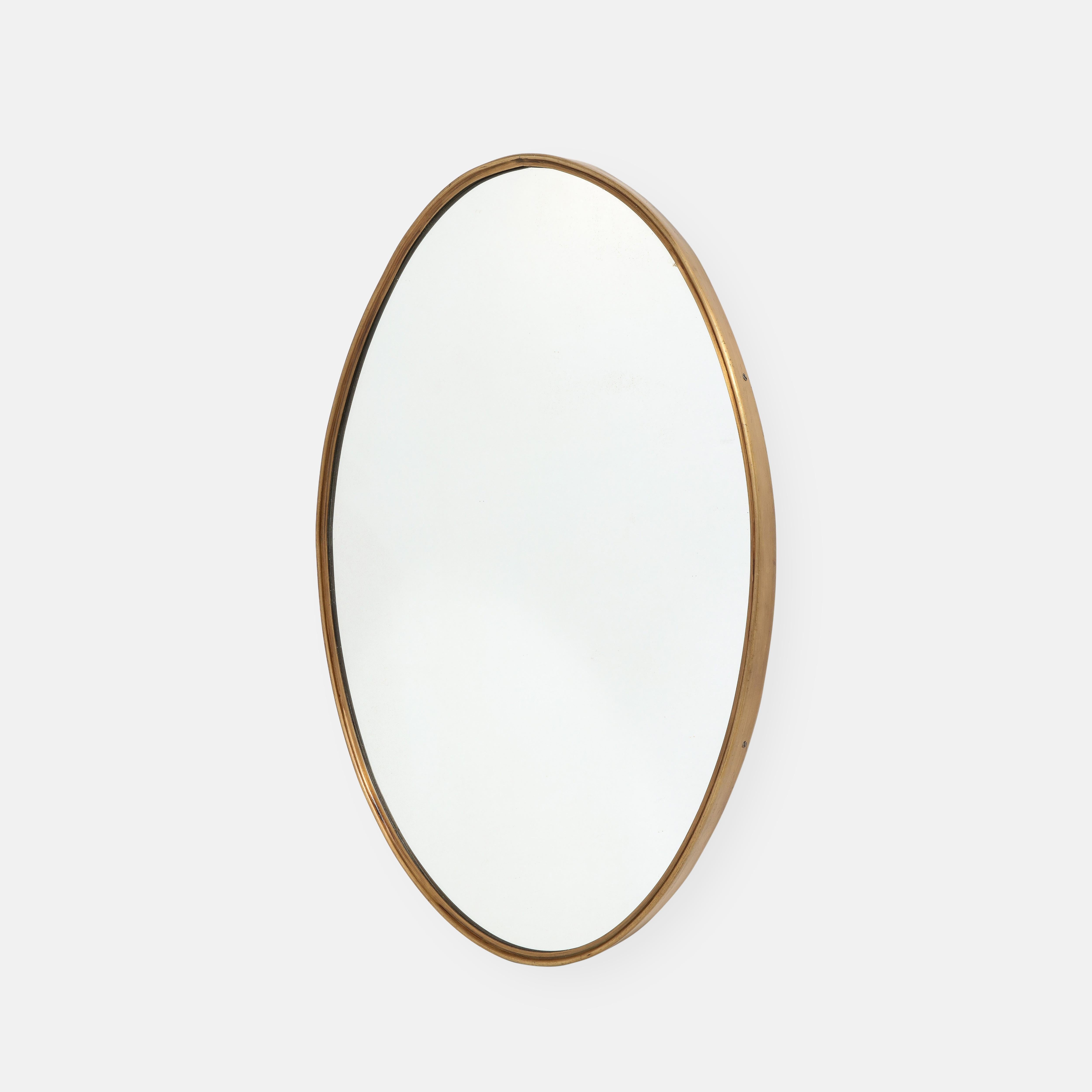 1950s Italian elegant oval brass wall mirror with a rich patina on the brass frame.  Finely constructed with wood backing.