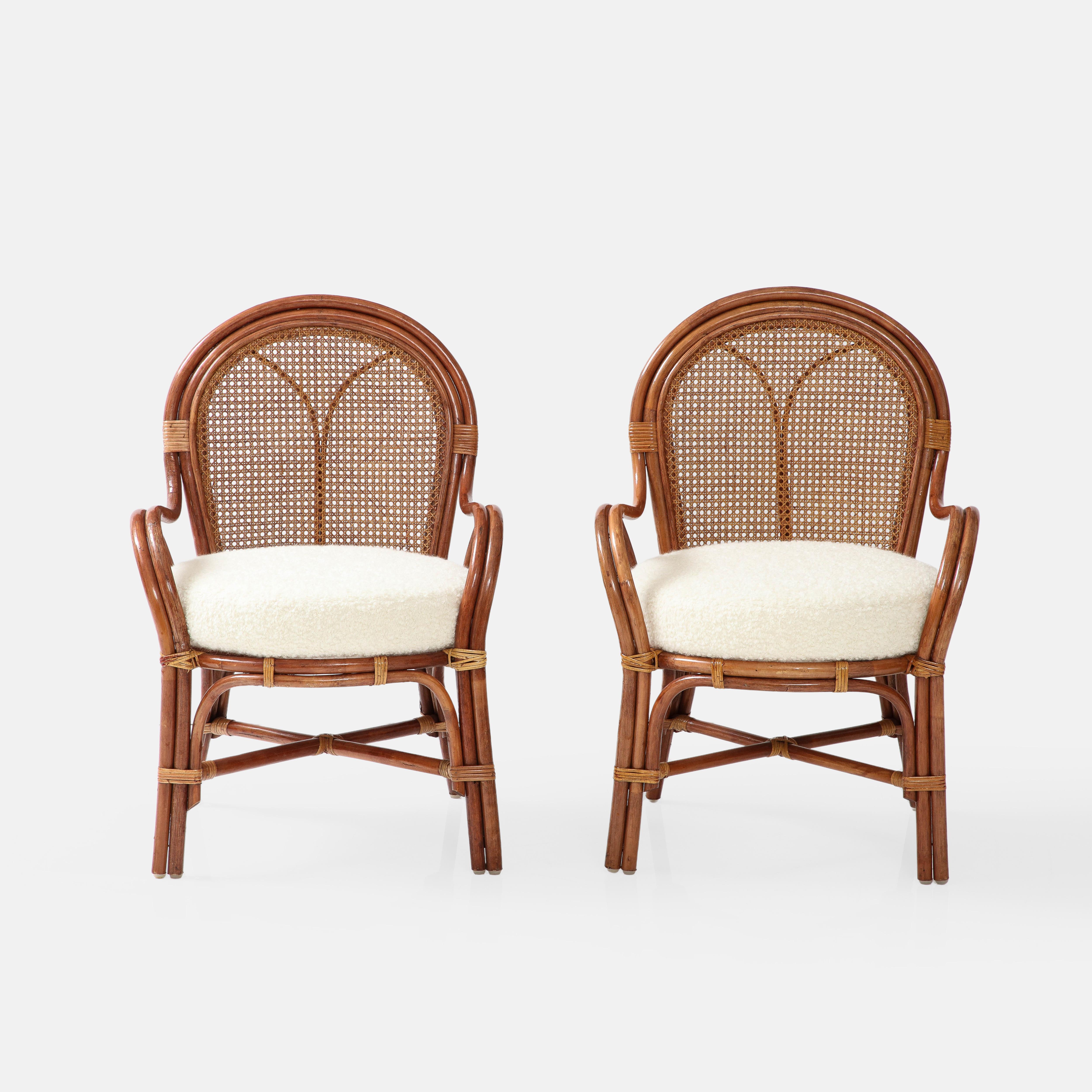 1950s Italian pair of bamboo and rattan armchairs with Vienna straw cane backs and ivory bouclé cushion seats.  This rarely seen vintage handmade armchairs exude elegance and charm in all the wonderful details. The organic bamboo frames are stained