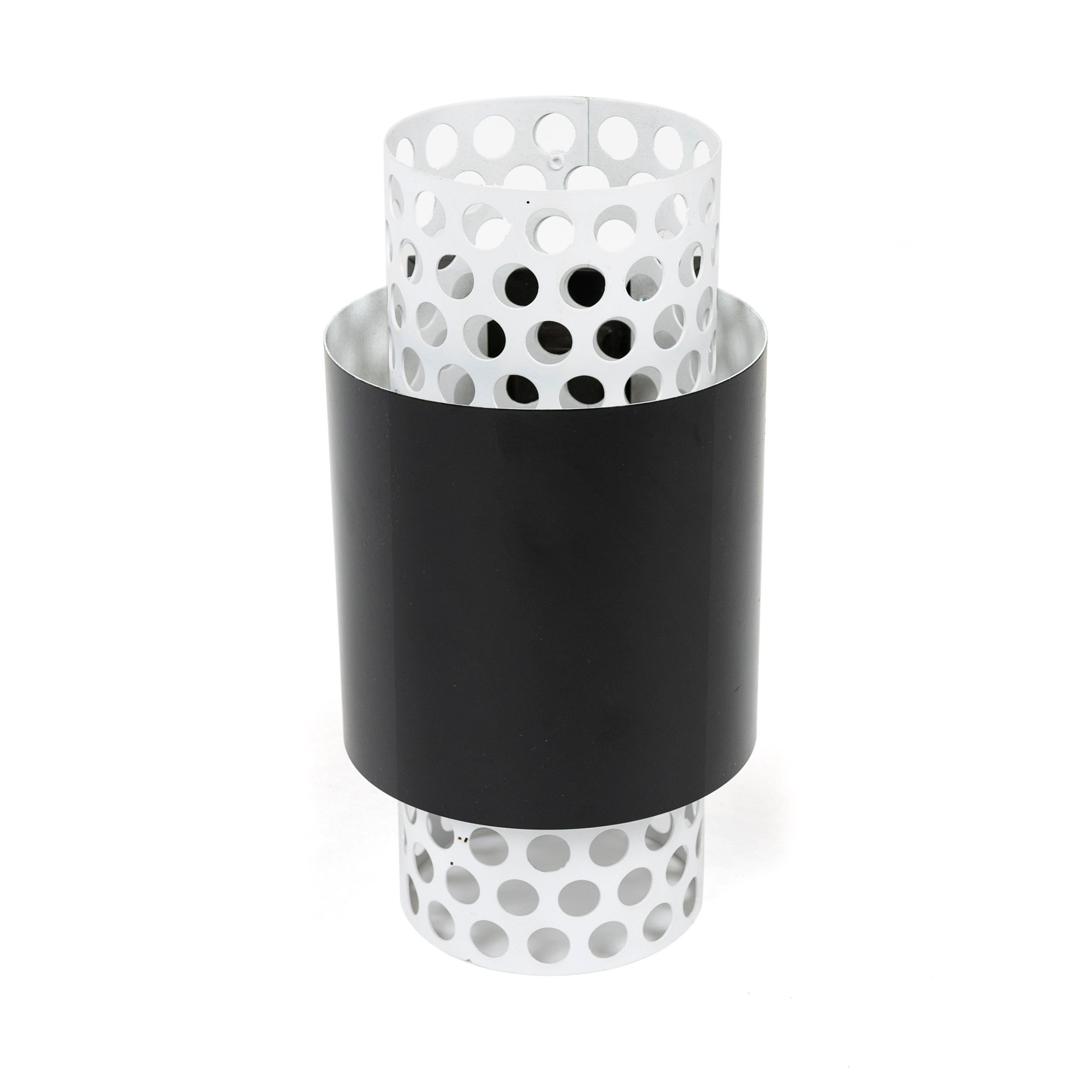 An uncommon wall sconce with a perforated tube core surrounded by a solid tube shade. Original white and black paint. Original Lightolier sticker and stamped 