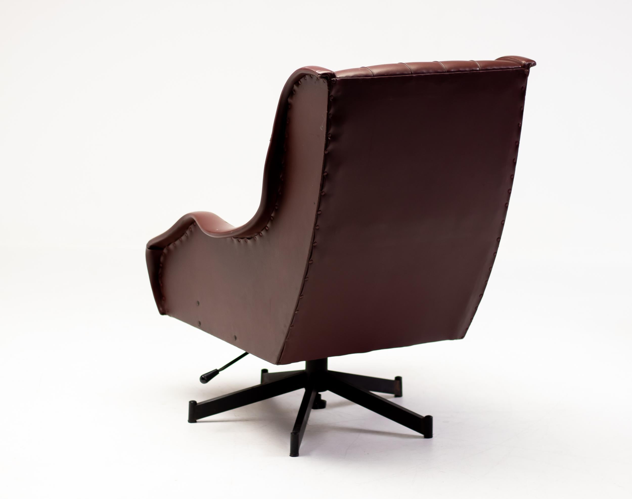 Sorprendente ejemplo del diseño italiano de mediados de siglo, este sillón reclinable de los años 50 combina la forma escultural con la comodidad cotidiana. Tapizada en Naugahyde color sangre de buey, la silla presenta elegantes líneas angulosas,