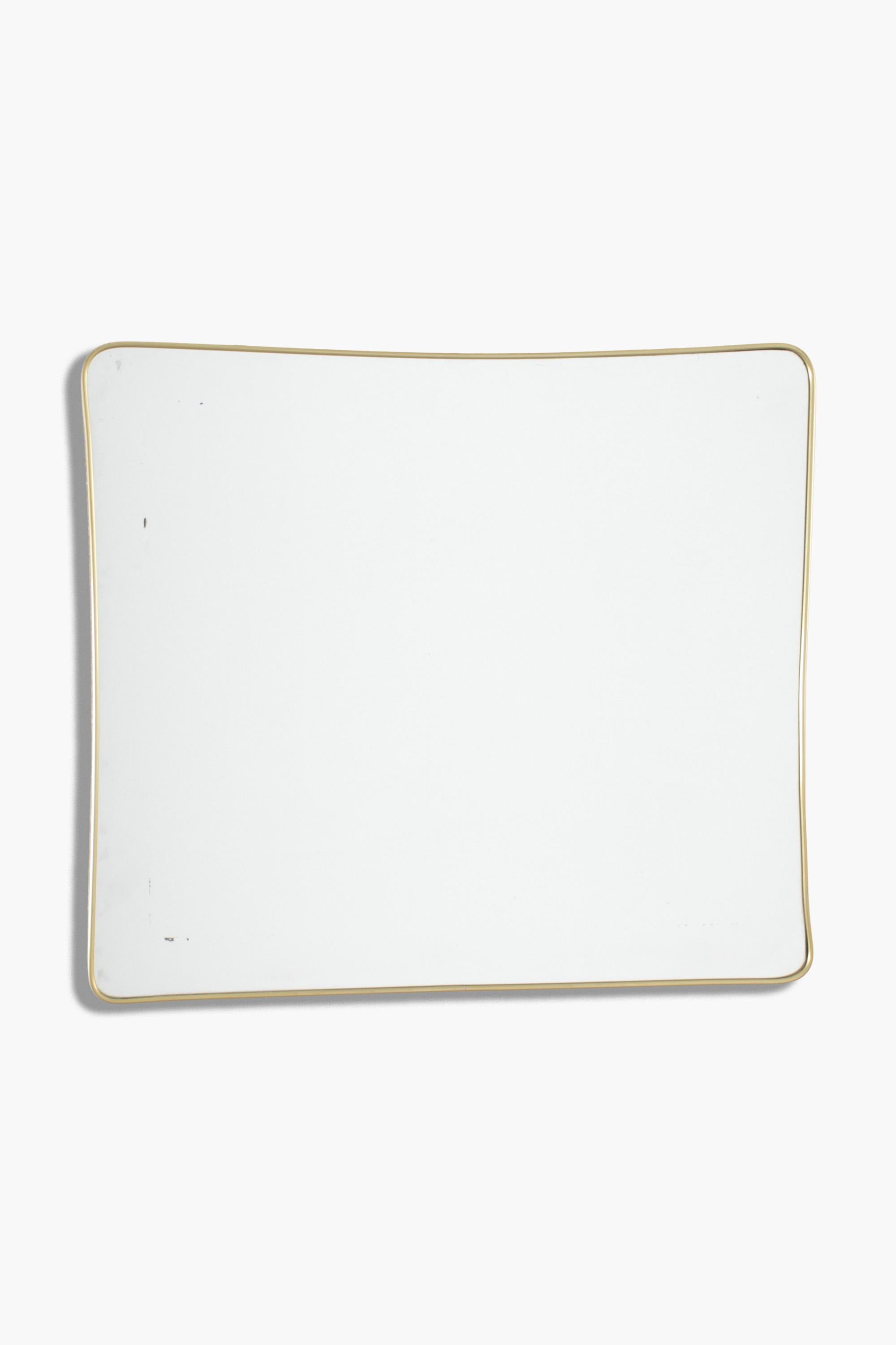 Miroir italien des années 1950 à encadrement en laiton doré, de proportions rectangulaires. Le sommet et les côtés verticaux sont légèrement incurvés.

Excellent état d'origine. La plaque de miroir d'origine présente de petites zones de rousseur,