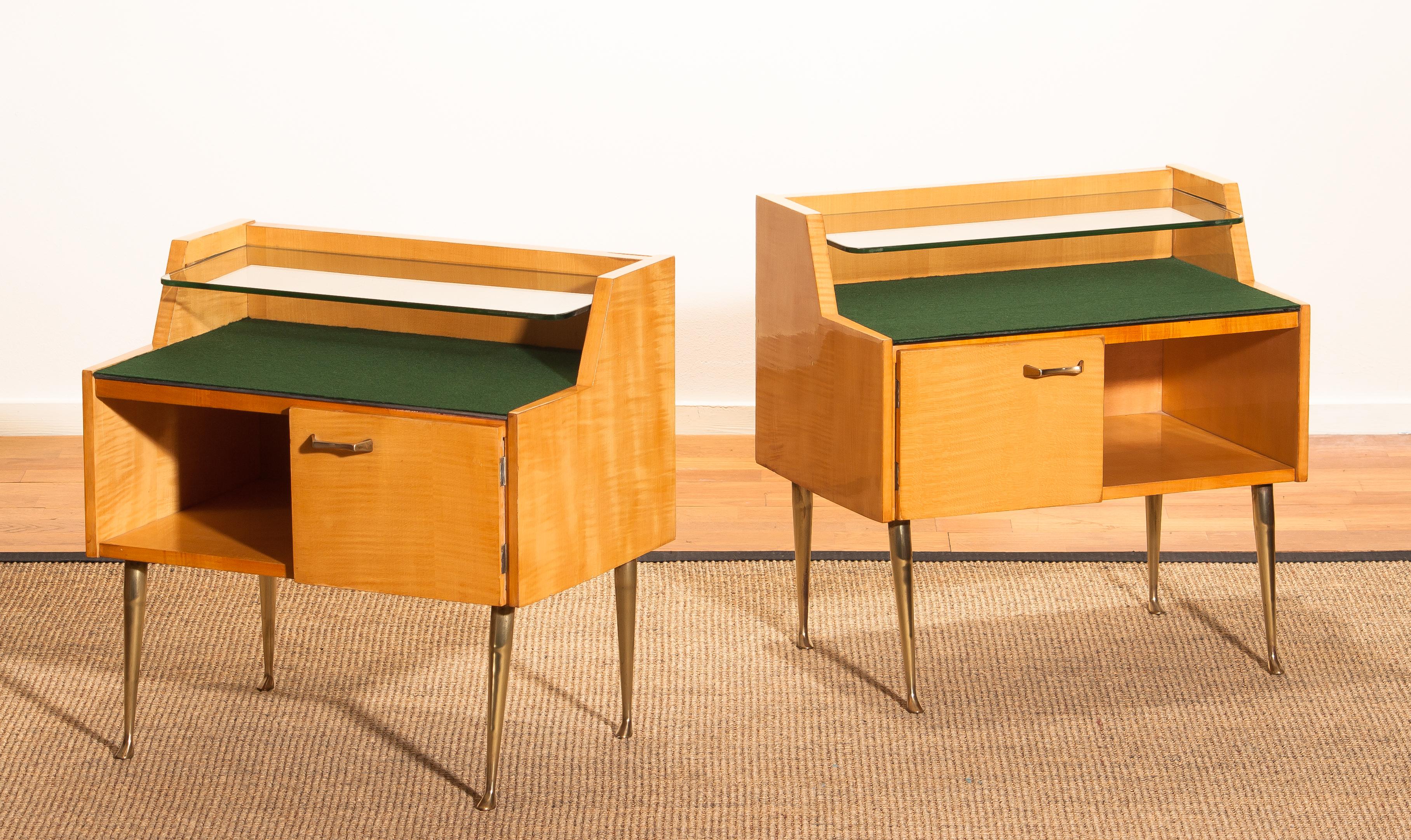 Beautiful set of two Italian midcentury bedside tables in maple with brass legs and brass handle designed by Paolo Buffa, Italy, 1950s.
Both are in good condition.
The top is covered with green felt and In addition there's a smaller glass shelf op