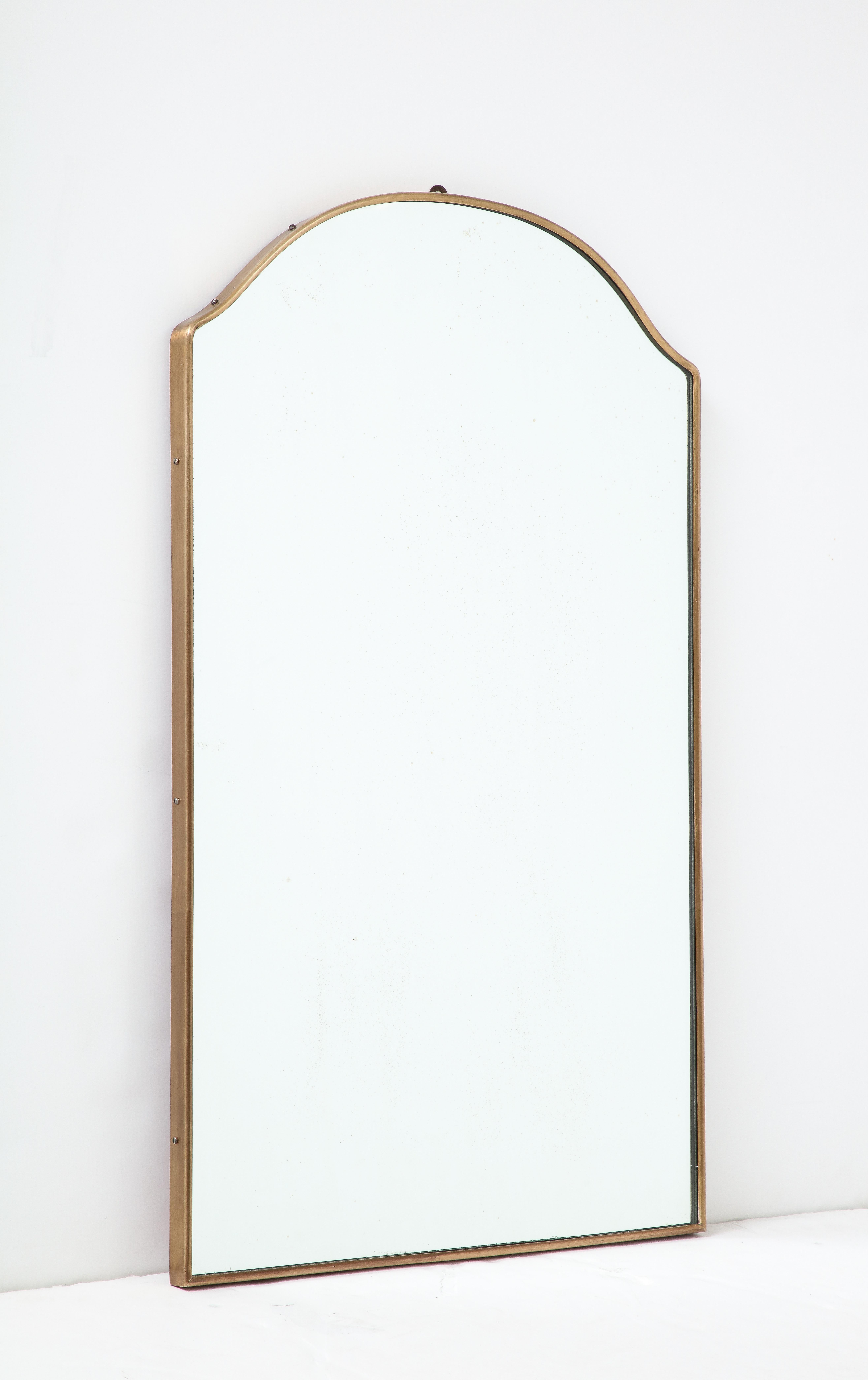1950s Italian elegantly shaped brass wall mirror with a beautifully arched top. The mirror has a nice brass patina and is finely constructed with a wood backing.