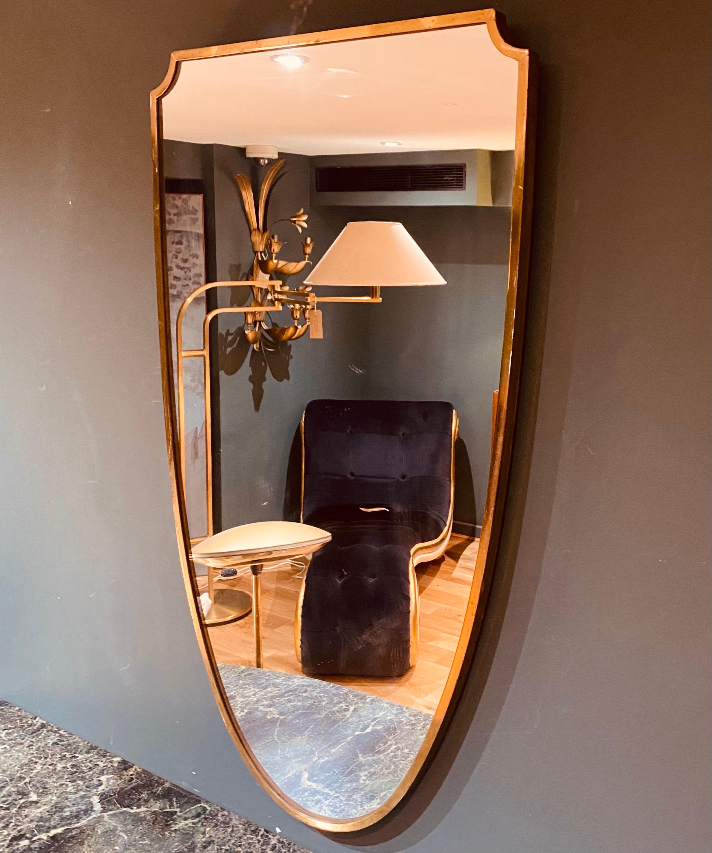 An elegant shield shaped mid century Italian brass surround wall mirror.