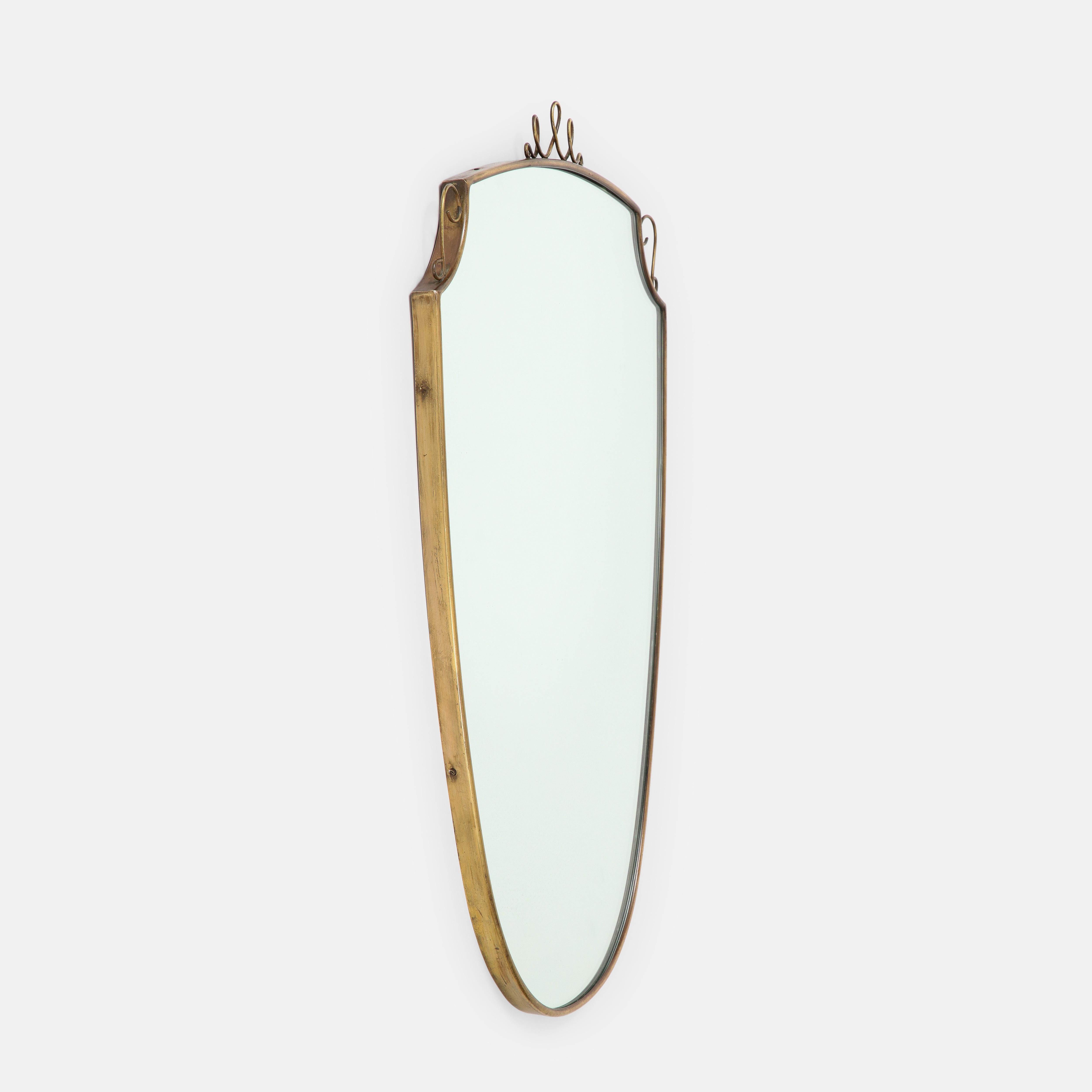 Mid-Century moderno Specchio italiano a forma di scudo in ottone con volute del 1950 in vendita