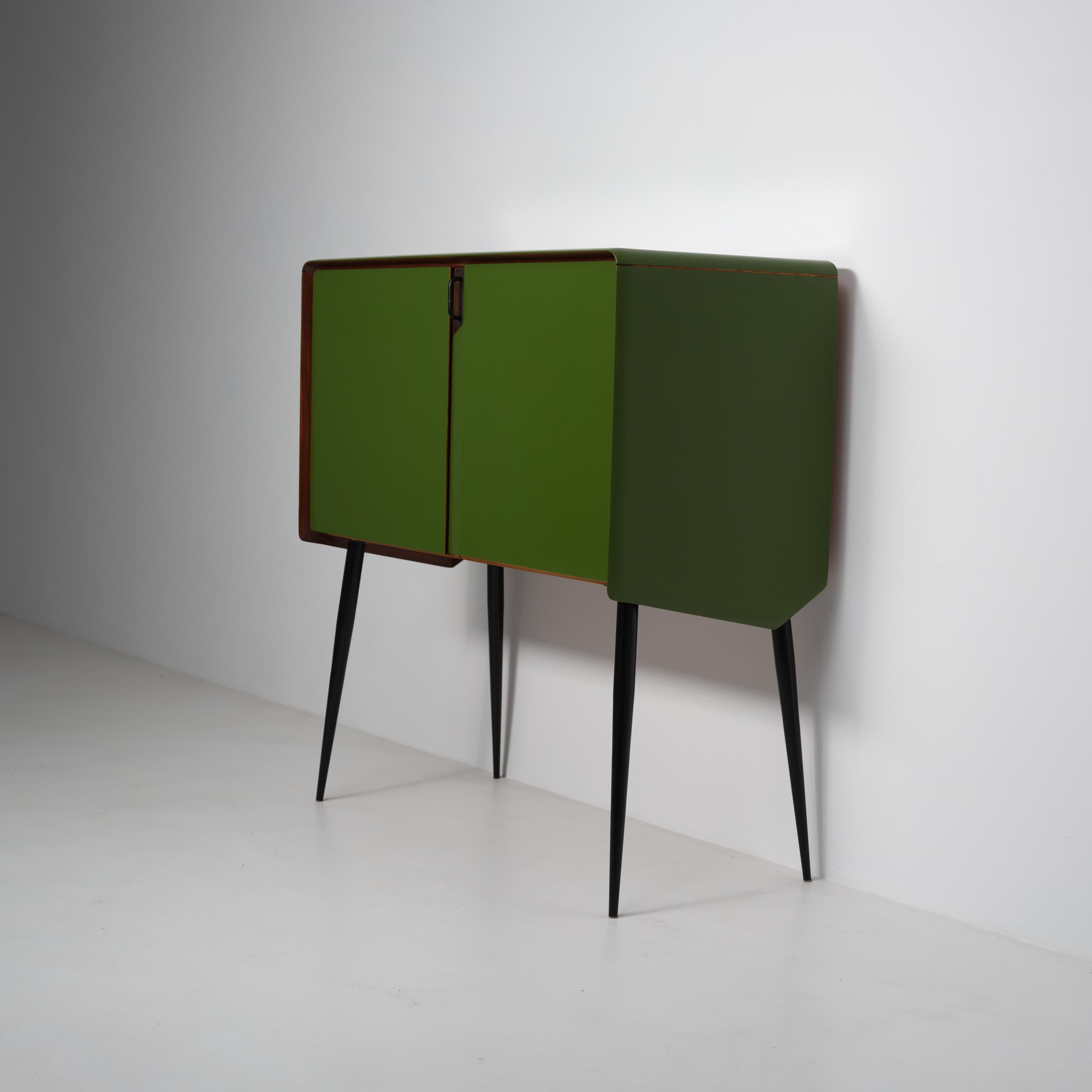 Italian sideboard from the 1950s, restored and restyled with great attention to craftsmanship and modern proportions. The structure is made of solid wood, finished with a green shellac lacquer that enhances the curved profiles and rounded edges. The
