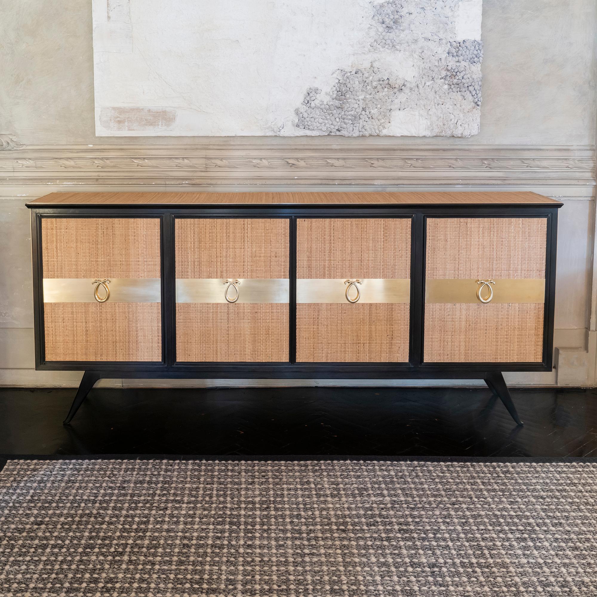 Sideboard in ebonized wood covered in rattan with original brass details and handles, interior in cherry wood, side sections with fixed shelves and a drawer, center section is a dry bar with a waves brass decor, 
perfect condition and vintage