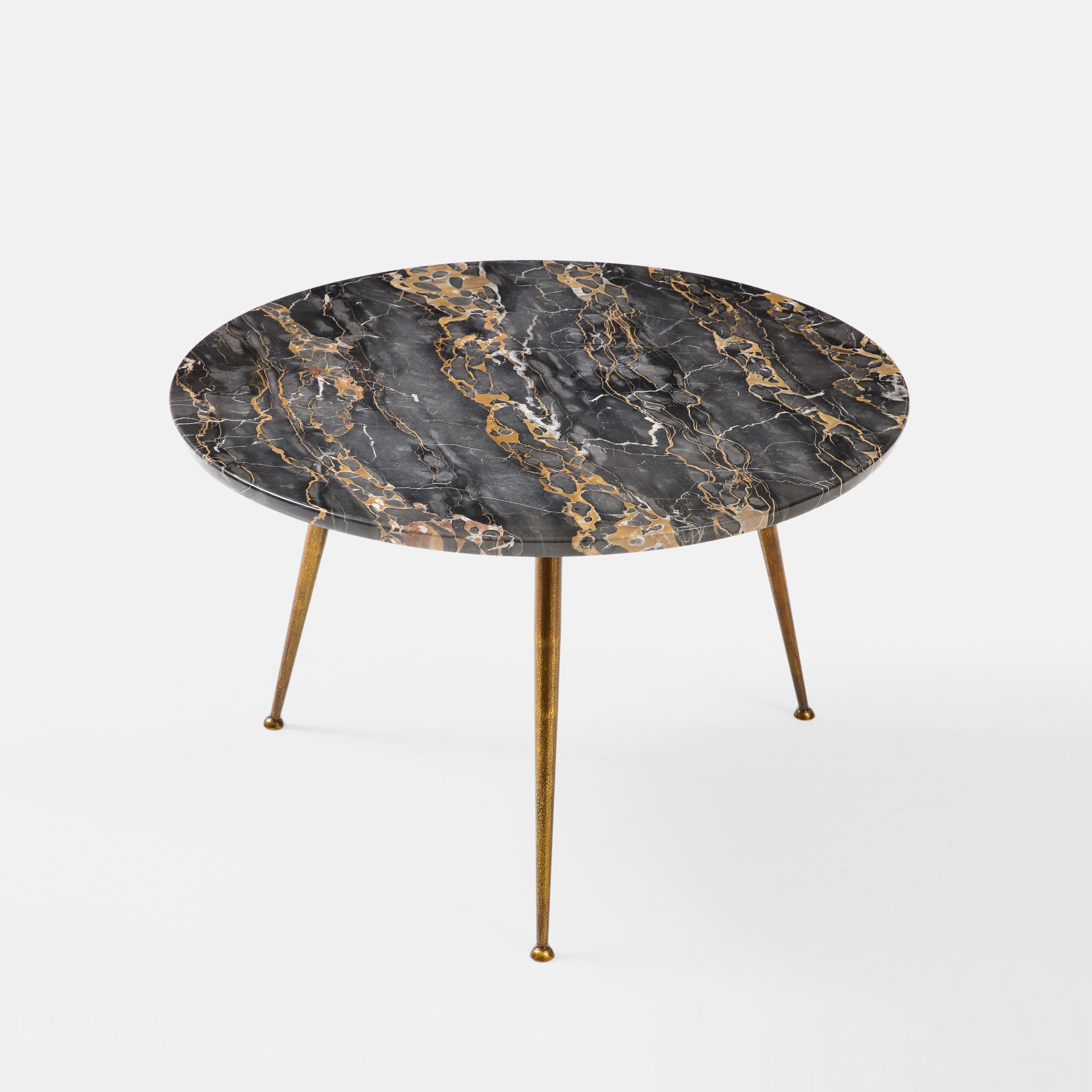 Beautiful small round coffee table with Nero Portoro marble top on tripod gilt metal legs, Italy, 1950s.  This chic marble coffee table exudes the charm and elegance of classic mid-century Italian design.

Nero Portoro marble, also known as black