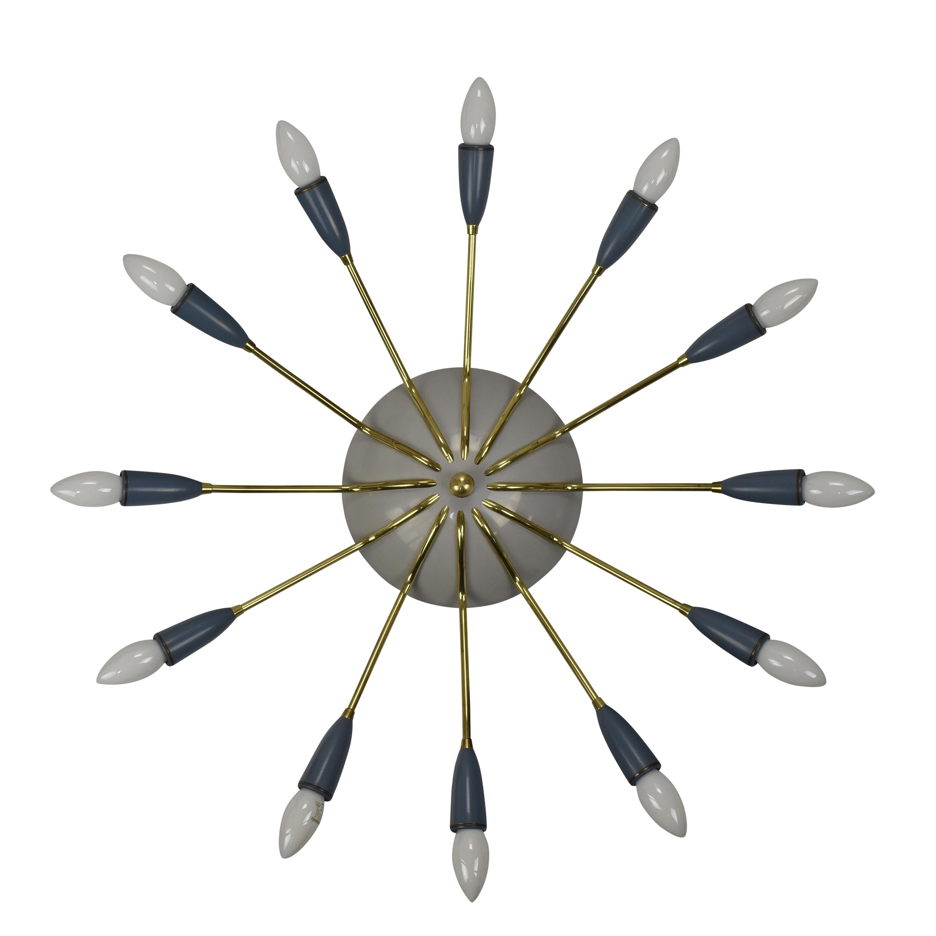 This large Sputnik chandelier, crafted in Italy during the 1950s, is an eye-catching piece of lighting. 

It boasts twelve brass arms, each adorned with an E14 light bulb. The design of the fixture bears a resemblance to a spider or sunburst, with
