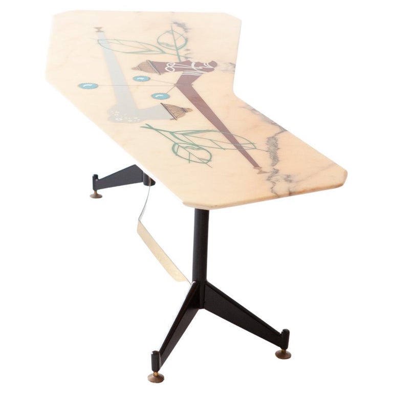 An elegant and modern coffee table, designed and produced in Italy in the 1950s.

The marble top is polygonal in shape and resembles that of a boomerang, its surface has been decoded with a stylized drawing .
The legs are in restored steel with a