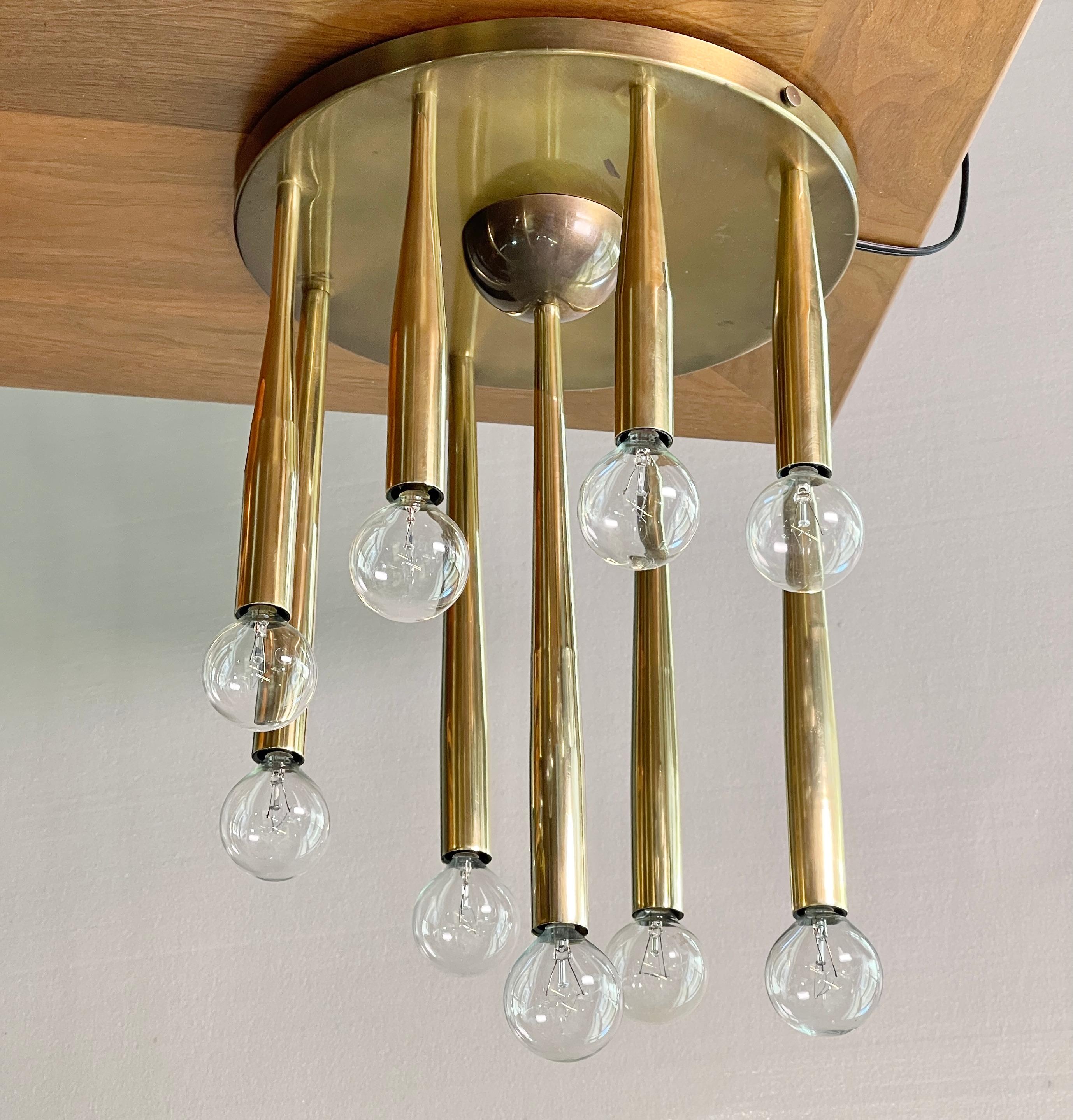 Very rare 1950's Italian ceiling flush mount light fixture attributed to Gio Ponti. 
The fixture consists of a 12 inch diameter round brass ceiling plate mounted, like candles on a birthday cake, by nine individual swage tapered solid brass