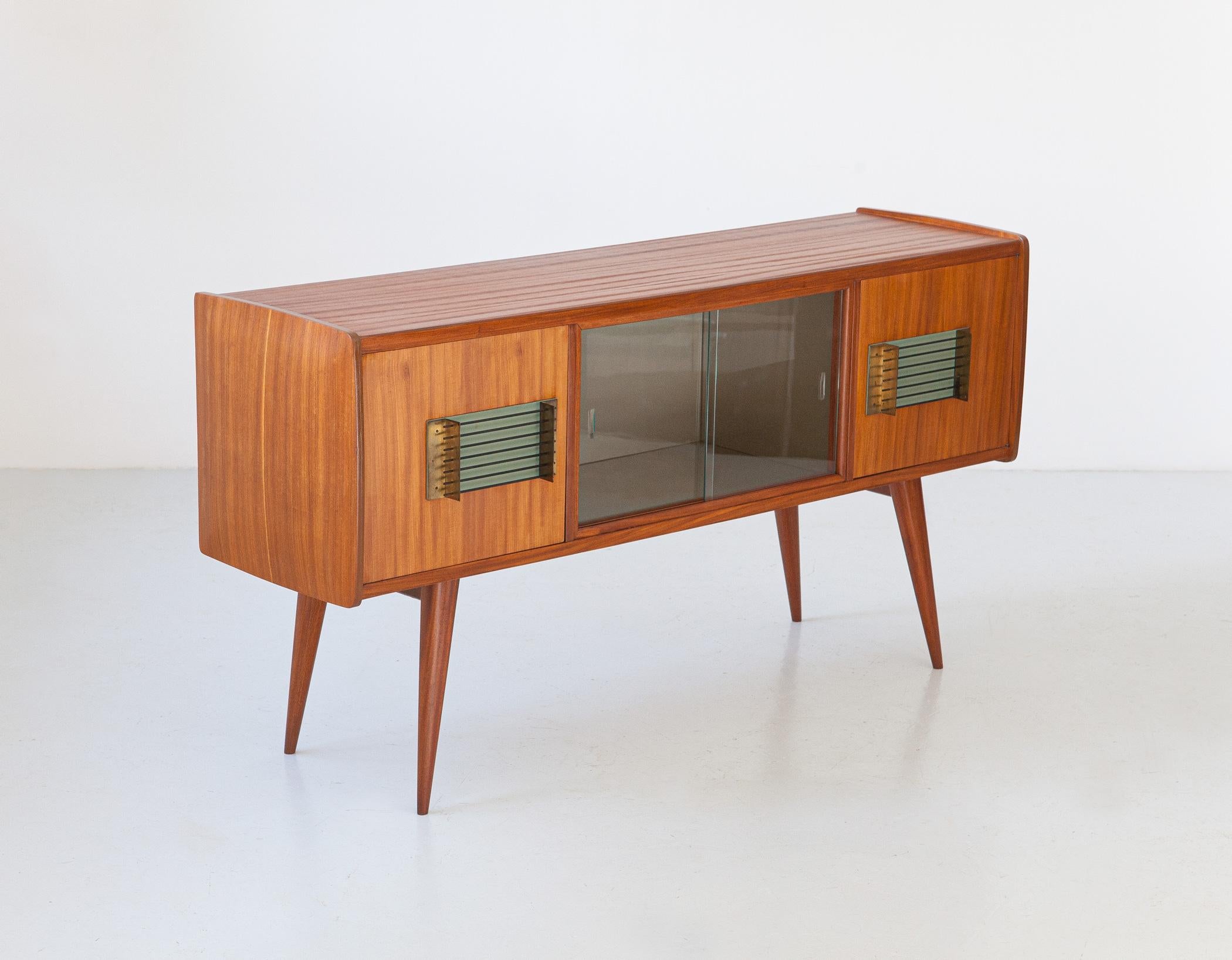 1950s Italian sideboard with bar in teak and brass 


This particular piece boasts an elegant design embellished with two large modern handles in iron and brass on a turquoise leather background. The impact design of the handles really works!
