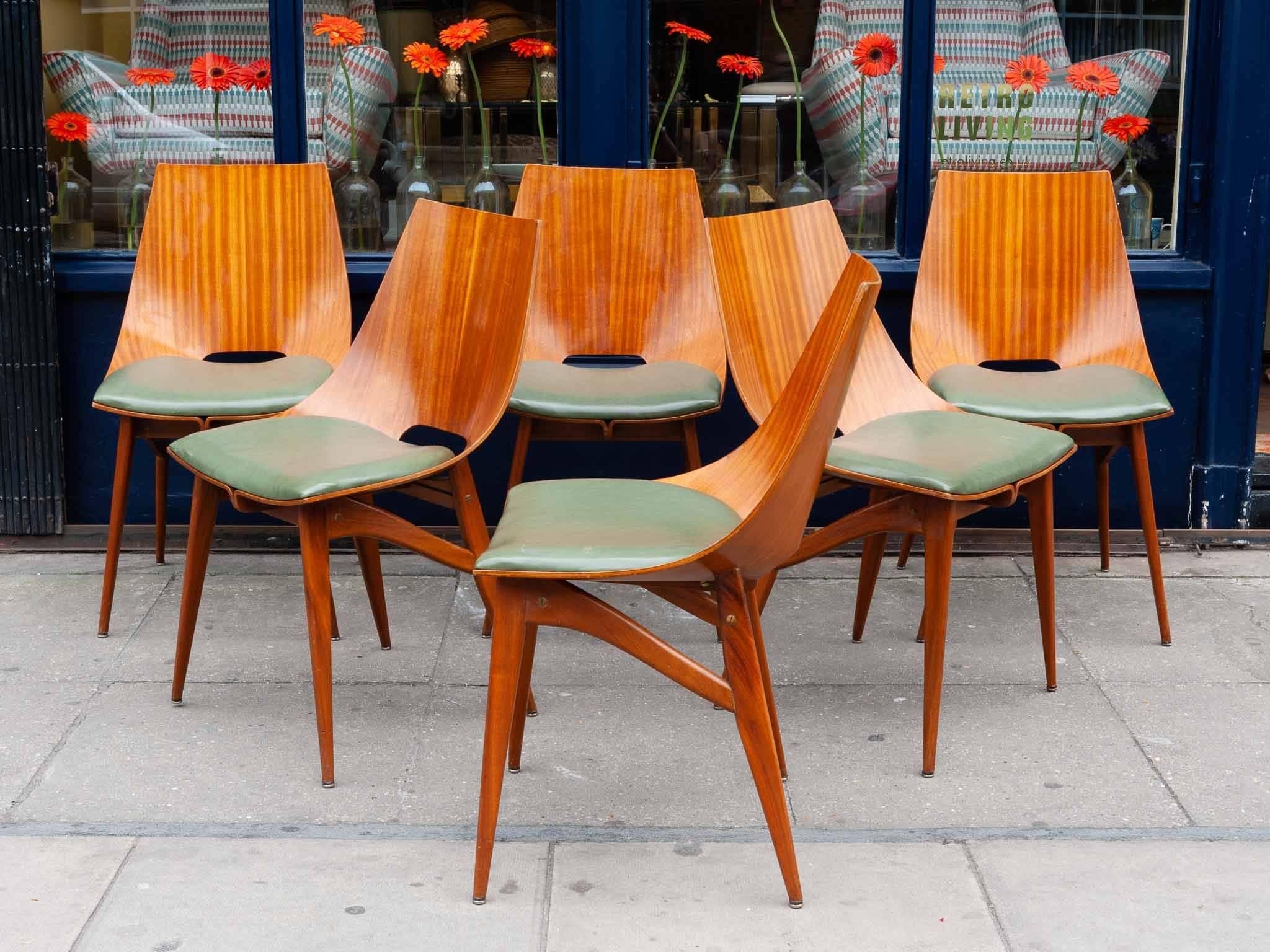 Set of six beautifully designed and intricately made bent plywood and solid Teak dining chairs. The one piece of bentwood curves and meets in a feature wave directly below the faux leather vinyl green seat. The four played legs are fixed to a frame