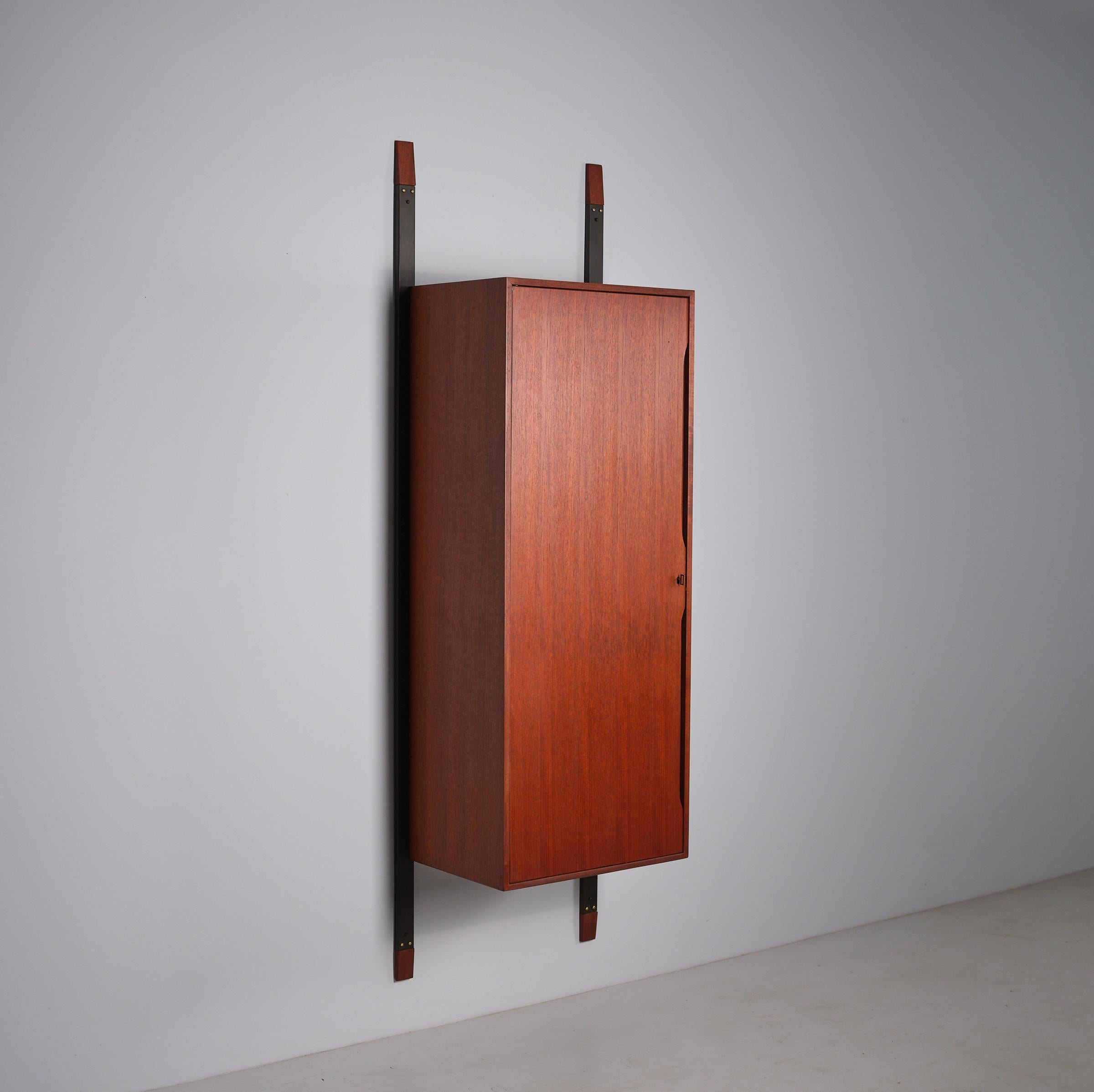 This minimalist wall unit wardrobe from the 1950s exemplifies classic Italian design, meticulously crafted from rich teak wood. Supported by two steel posts anchored firmly to the wall with four anchors, the unit combines stability with a sleek,