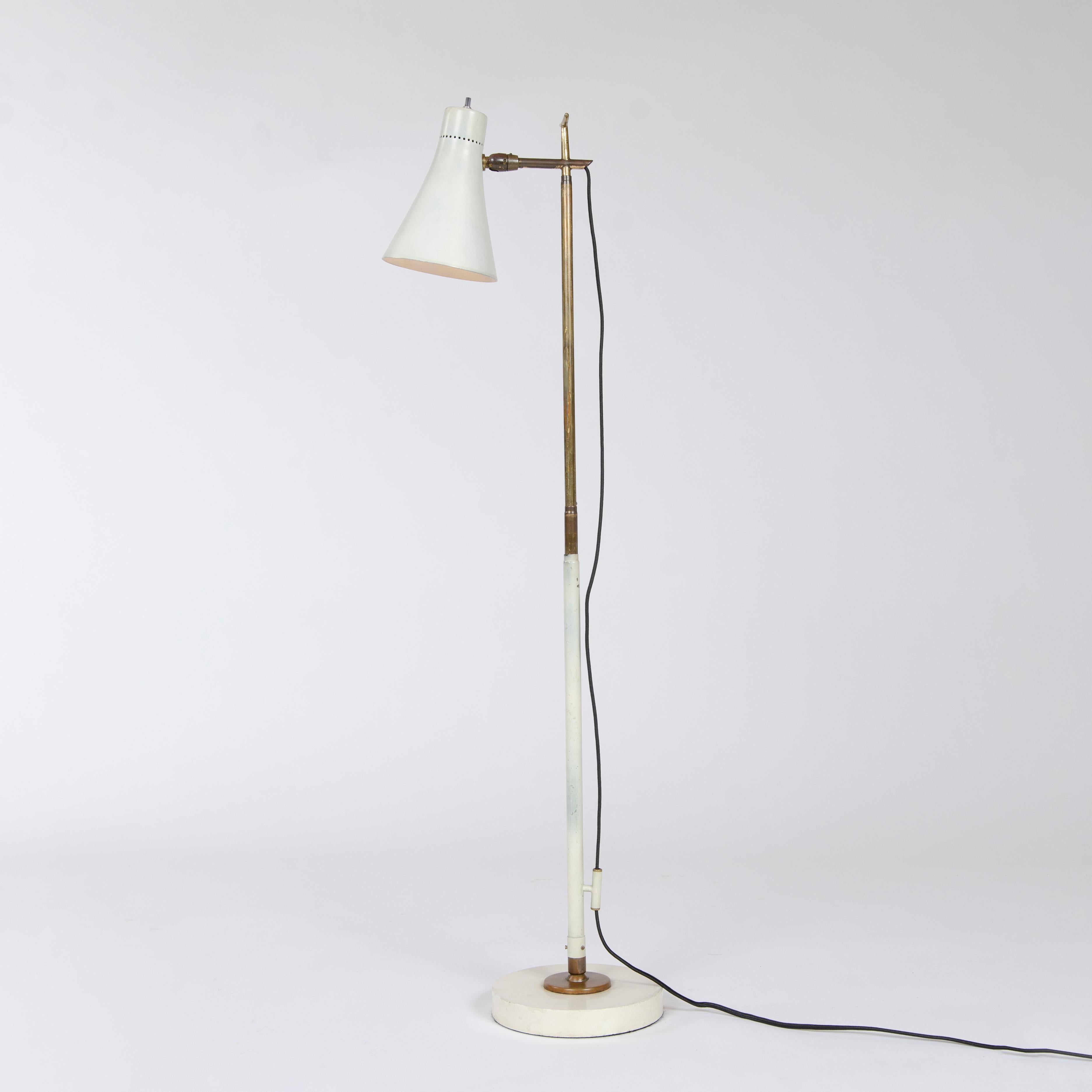 An early telescoping floor / desk lamp with a pivoting cone shaped shade on a brass and enameled steel stem with a ball-and-socket jointed disc base.
