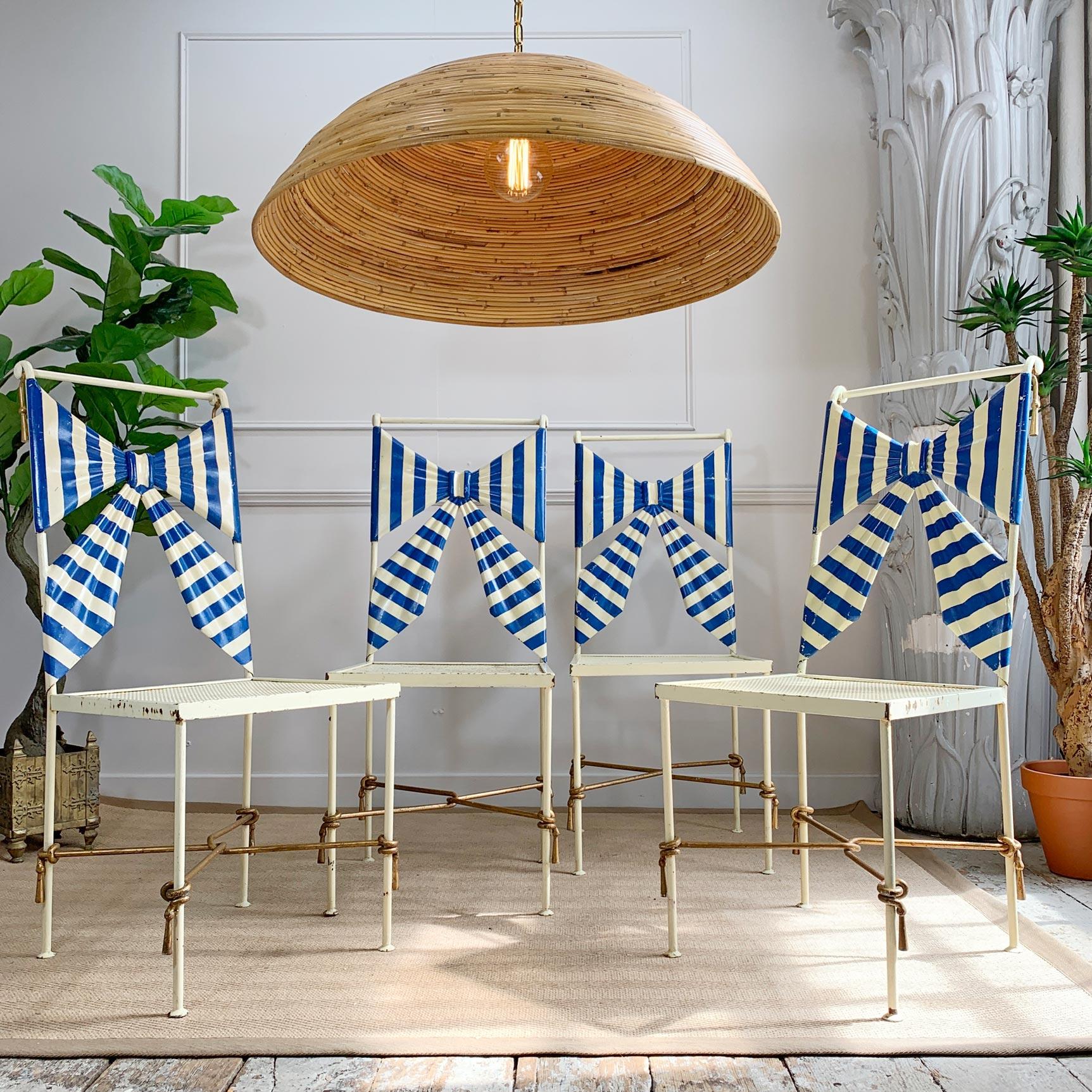 A fabulous set of four wrought iron 1950's Italian tole chairs, with hand painted blue and white rippled 3 dimensional bow back rests, gilt faux tassel decoration and perforate seats. This beautiful set of seats is incredibly rare and were most