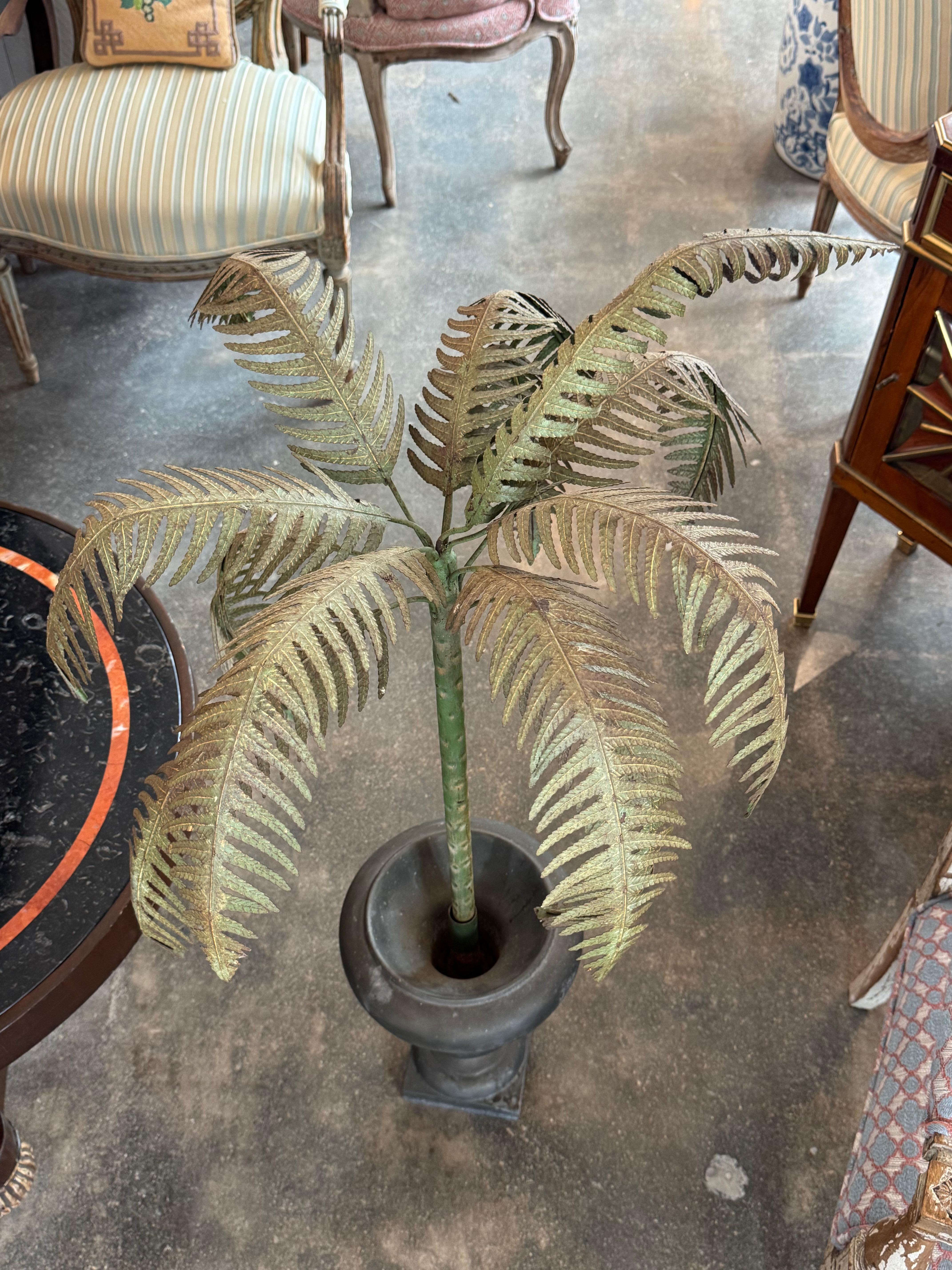 Whimsical and sculptural, this Italian tole palm features finely shaped fronds with naturalistic patina, rising from a heavy black-painted cast iron urn. A dramatic decorative accent that blends neoclassical form with a tropical flourish.