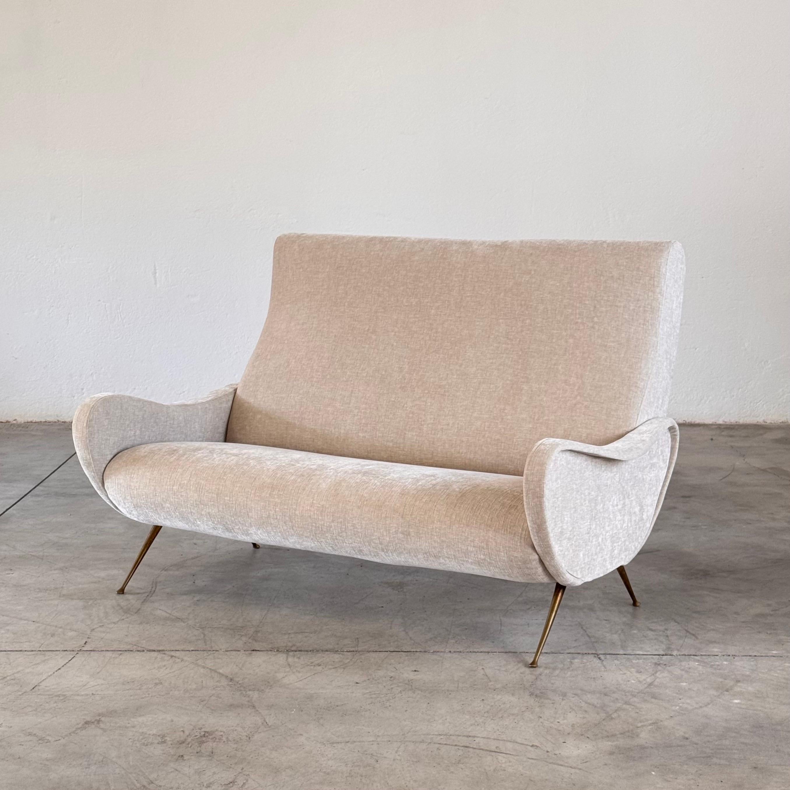 Questo divano a due posti italiano degli anni '50, disegnato da Gigi Radice e prodotto da Minotti, cattura la morbida eleganza e il fascino scultoreo del design italiano di metà secolo. Con le sue linee arrotondate, la scala intima e i braccioli