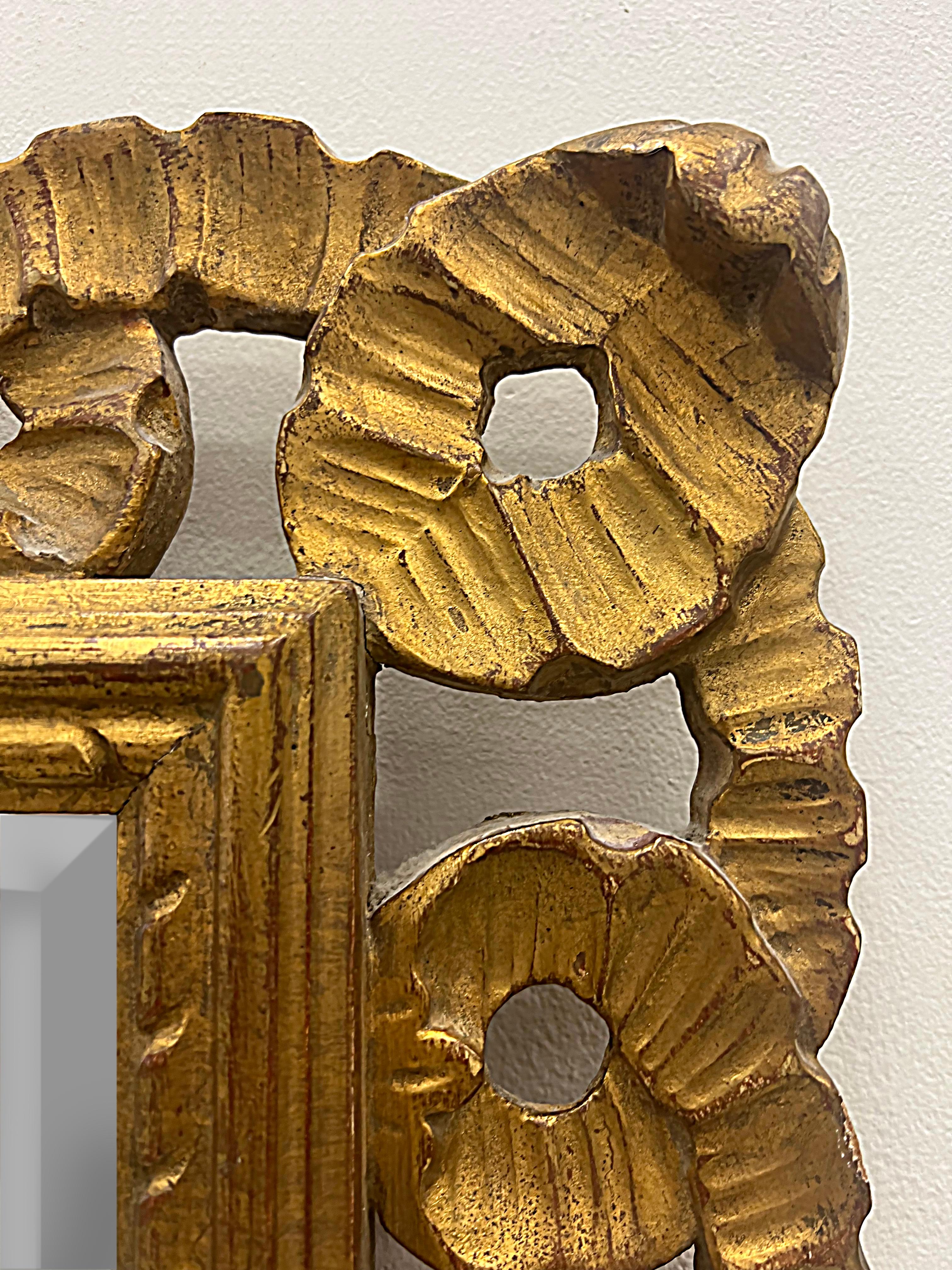 1950s Italian Venetian carved giltwood ribbon wall mirror.

Offered for sale is a vintage 1950s Italian Venetian hand-carved wood wall mirror featuring a fluted ribbon design and a beveled mirror. The carved wood frame has a gesso and gold