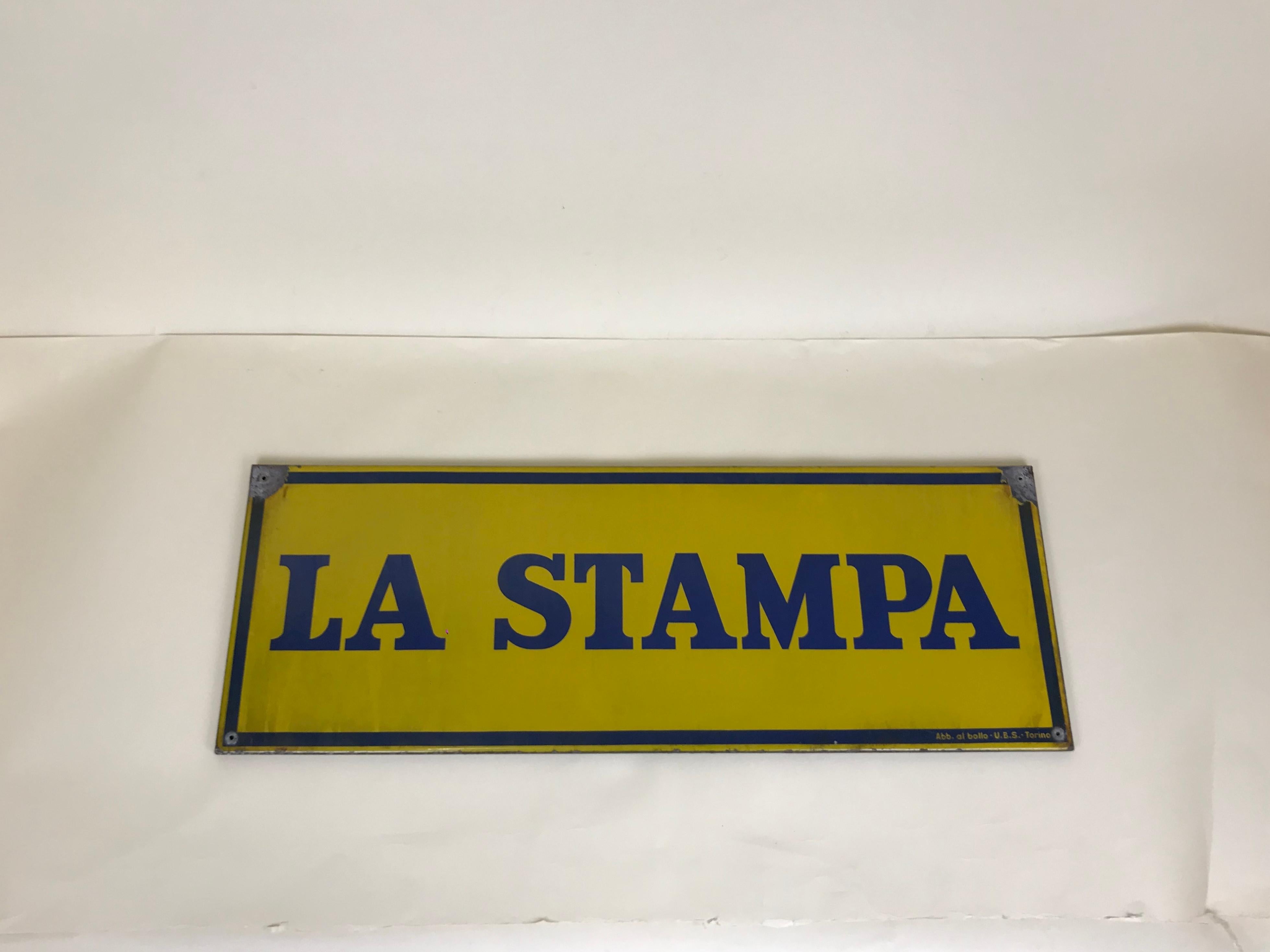 1950s enamel blue and yellow La Stampa sign.

Produced by U.B.S. Torino, Italy. Signed 