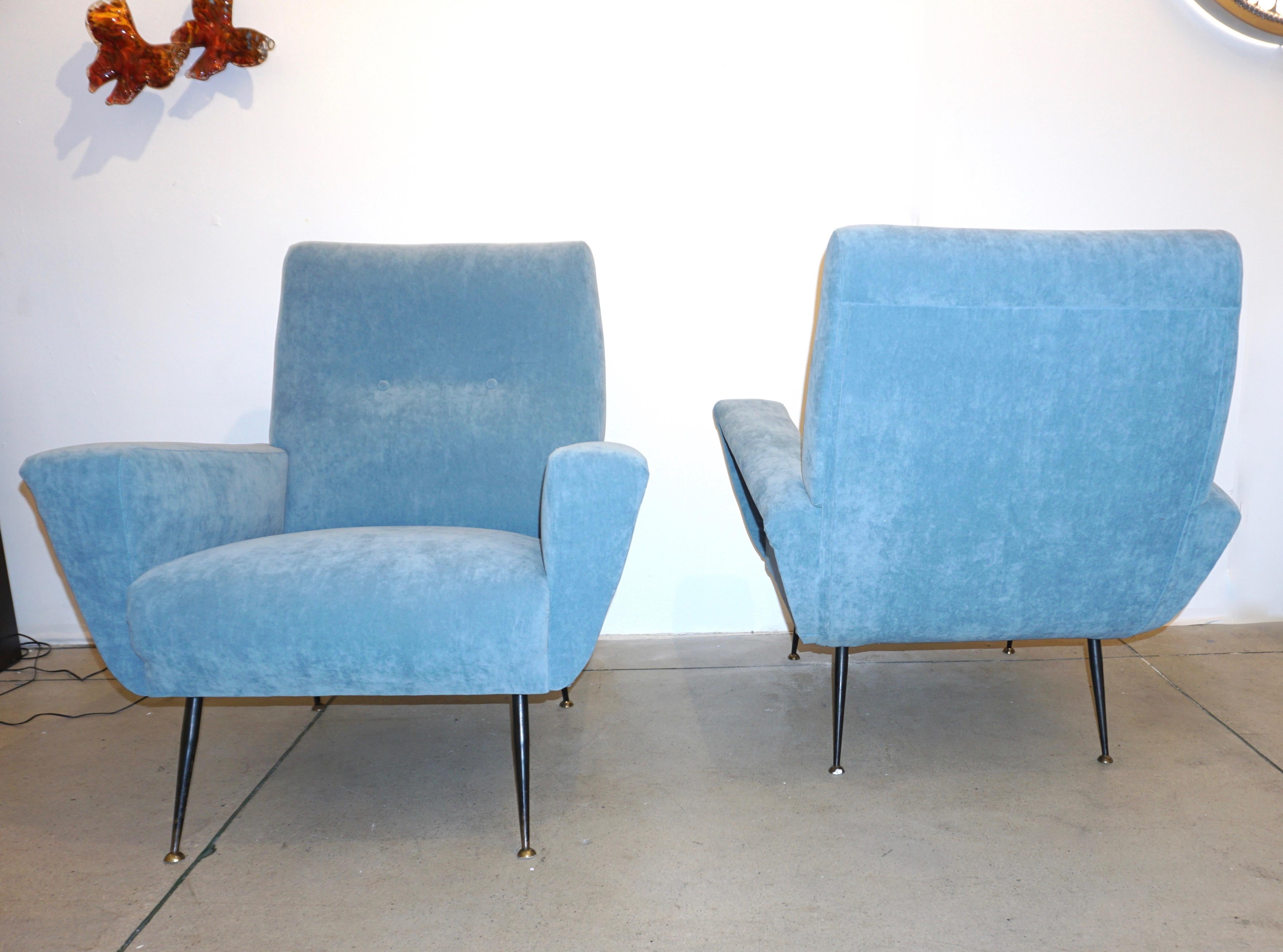 An elegant Italian Mid-Century Modern pair of very comfortable living room armchairs of great execution, the design is superb with a slightly curved back and the side edges protruding to create the armrests and to enhance the shape, reupholstered in