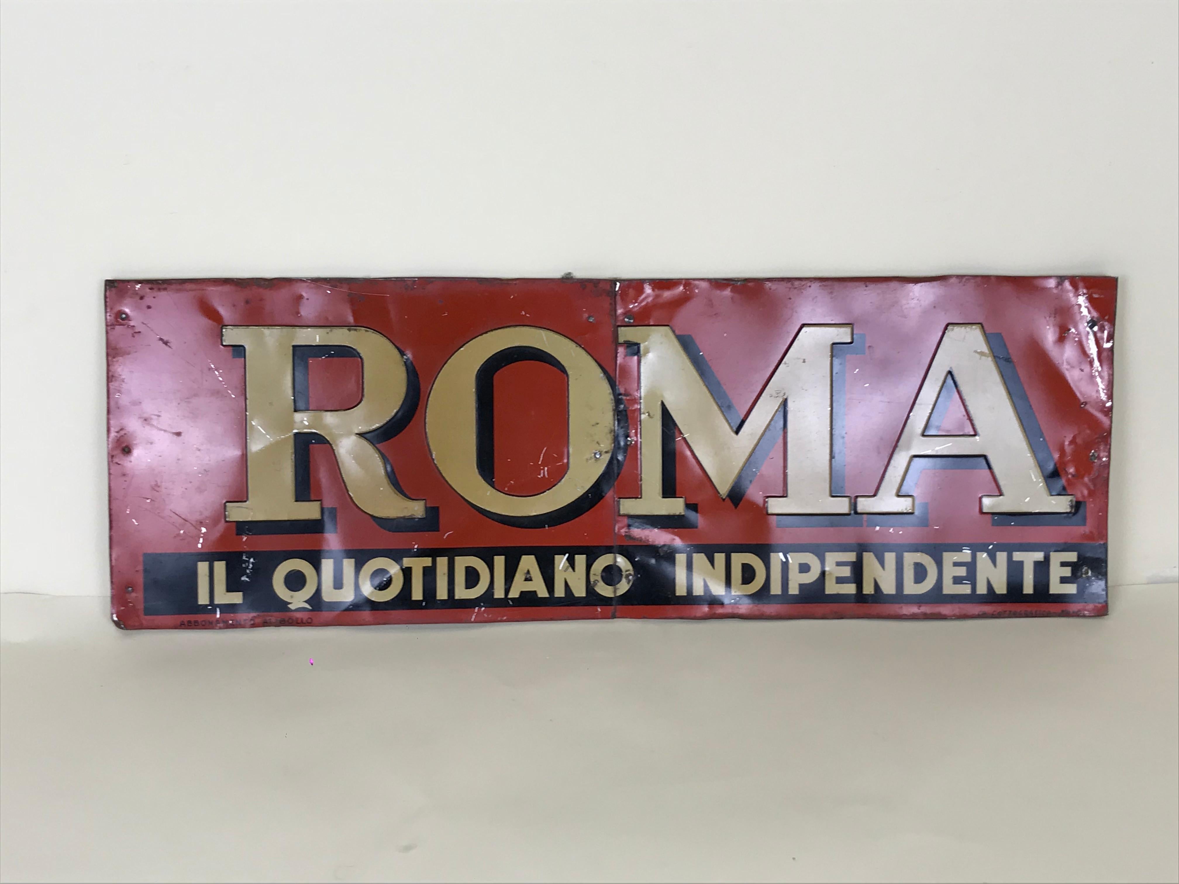 1950s transfer printed red and cream Roma newspaper sign.

The metal sheet sign is divided in two parts and assembled on a wooden board.

The letters of the newspaper logo °Roma° are relief printed while the slogan 