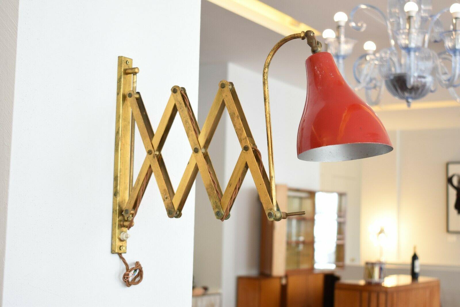 This 1950s Italian sconce holds great character and style. Its extendable brass scissor arm has a gorgeous antique patina while the red aluminium shade provides a burst of colour to any interior.

Dimensions:
Fully extended : 74cm 
Height of