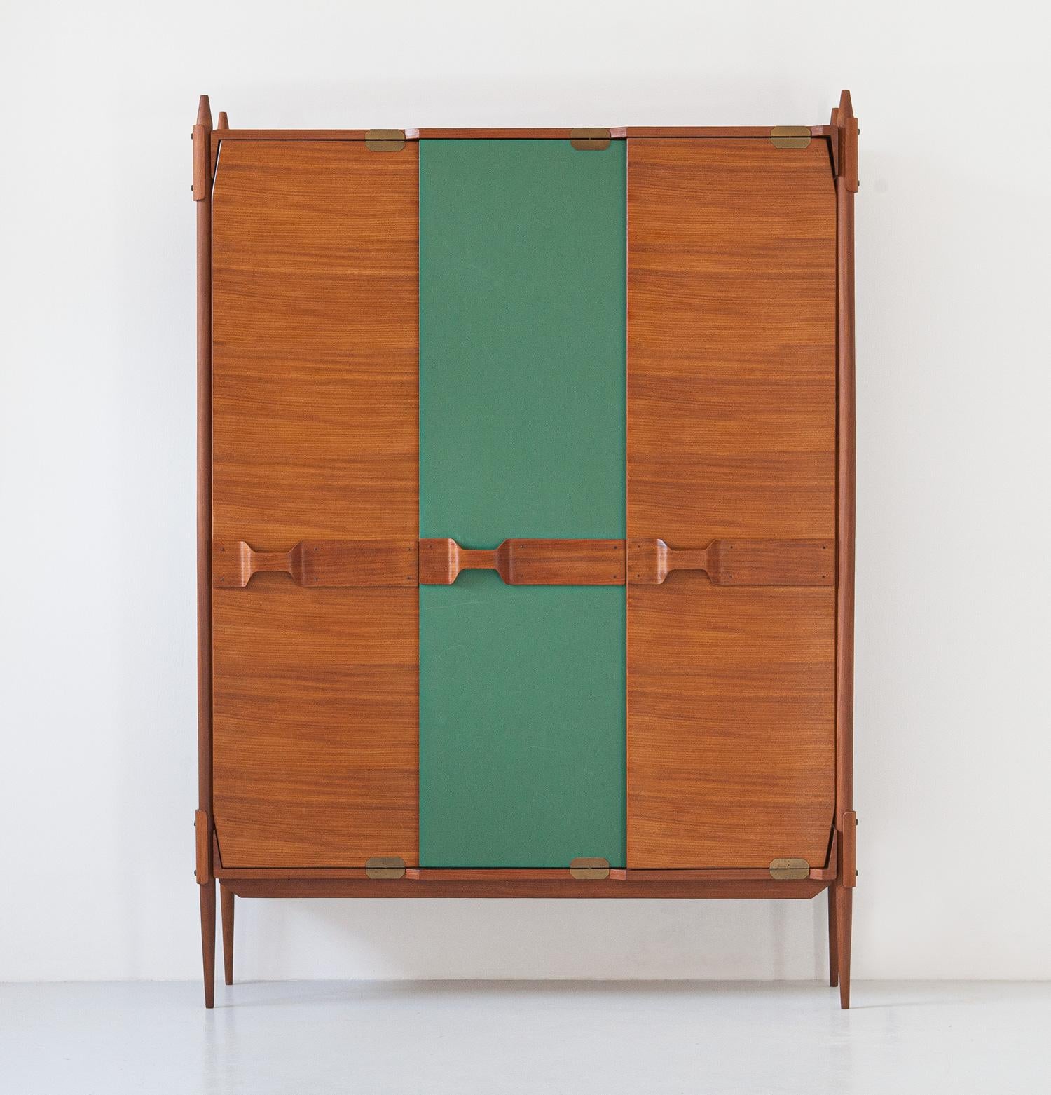 Italian Wardrobe, teak, green skay, brass, 1950s

This incredible piece of mid-century modern Italian design boasts ultra modern lines along with technical details of high Italian carpentry.

it has six brass and teak wood hangers. The three